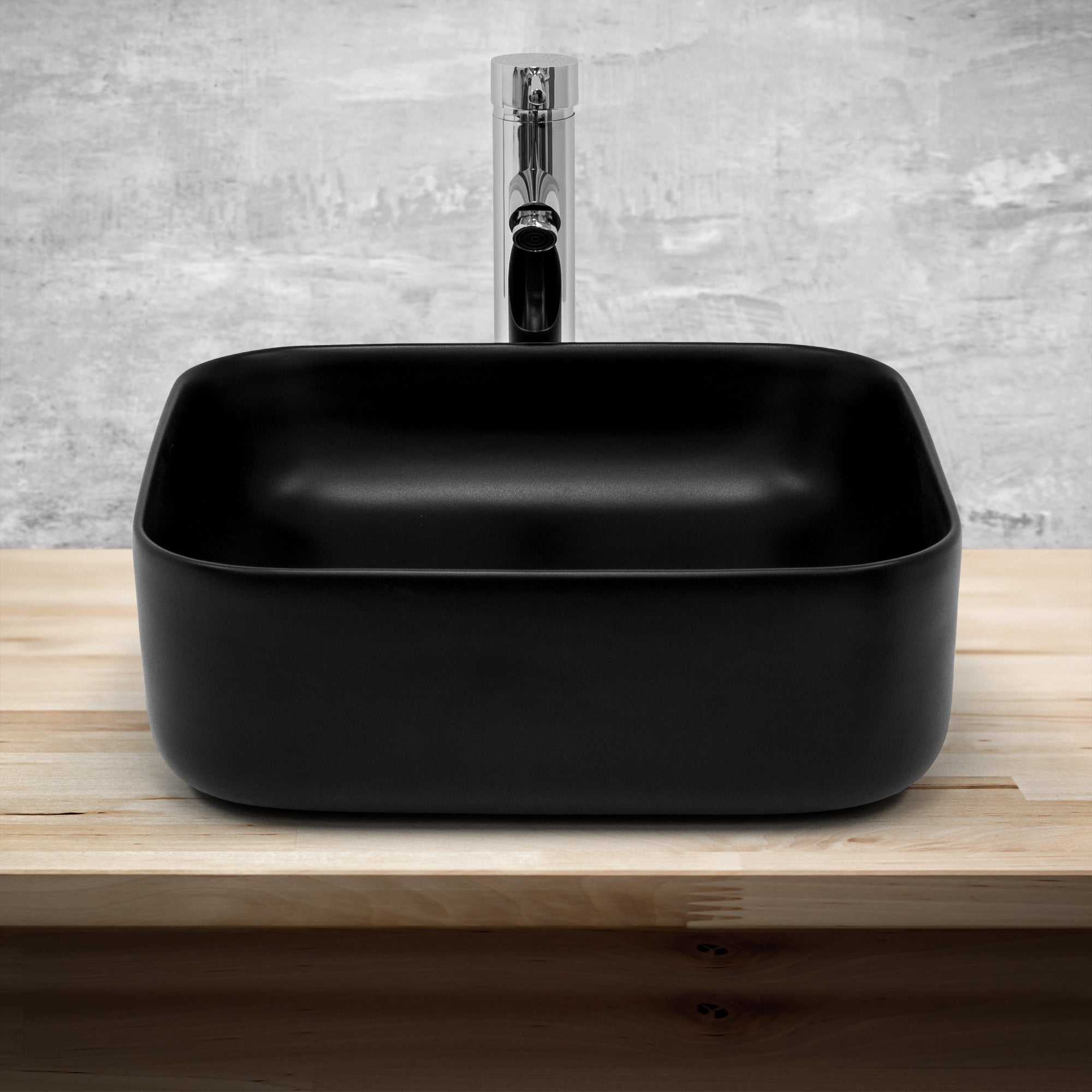 Black square washbasin on wooden background.