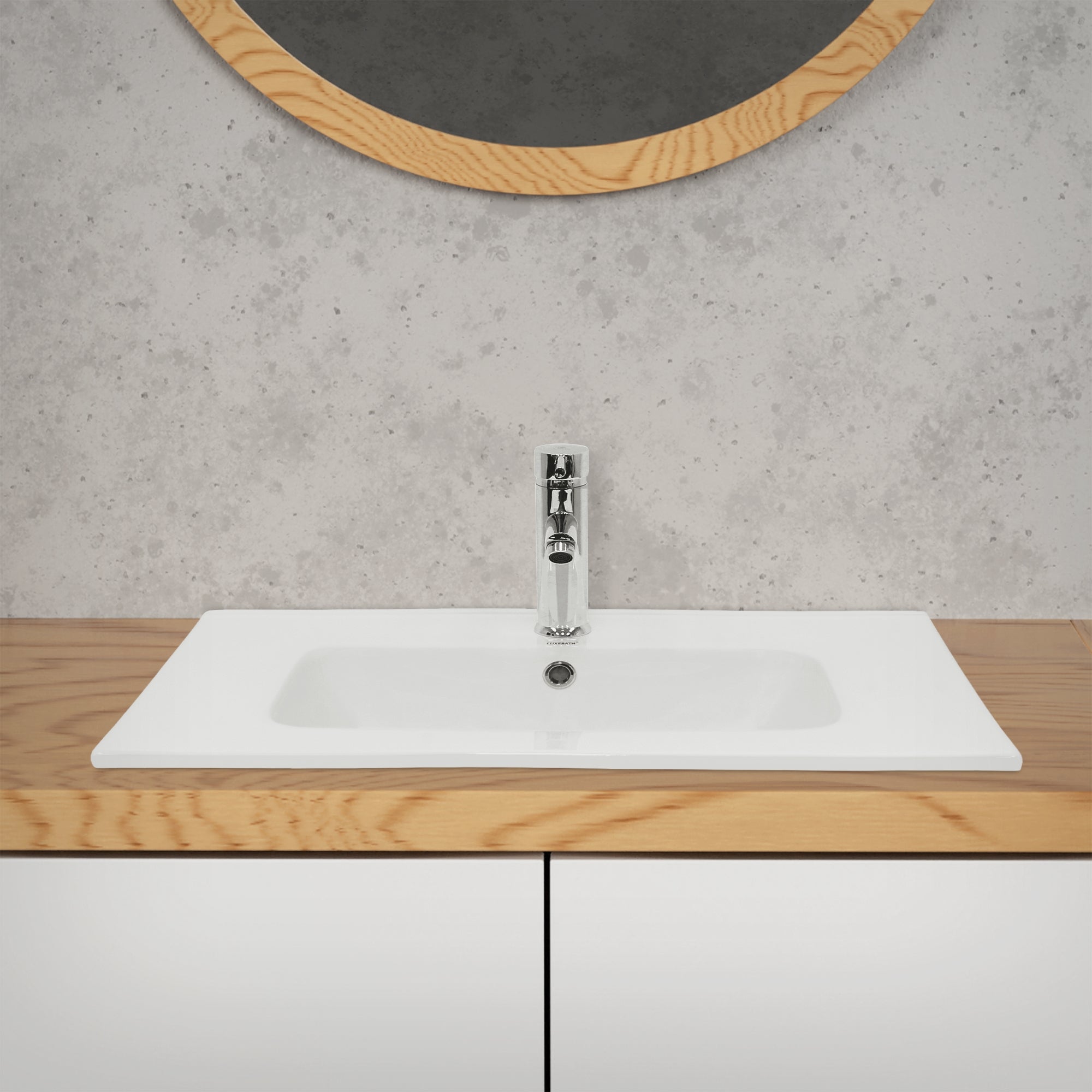 Waschbecken auf einer Holzplatte mit einem runden Spiegel im Hintergrund.