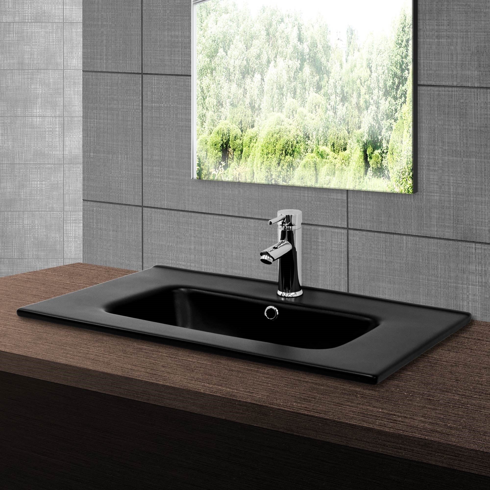 Black sink with faucet in front of a window.
