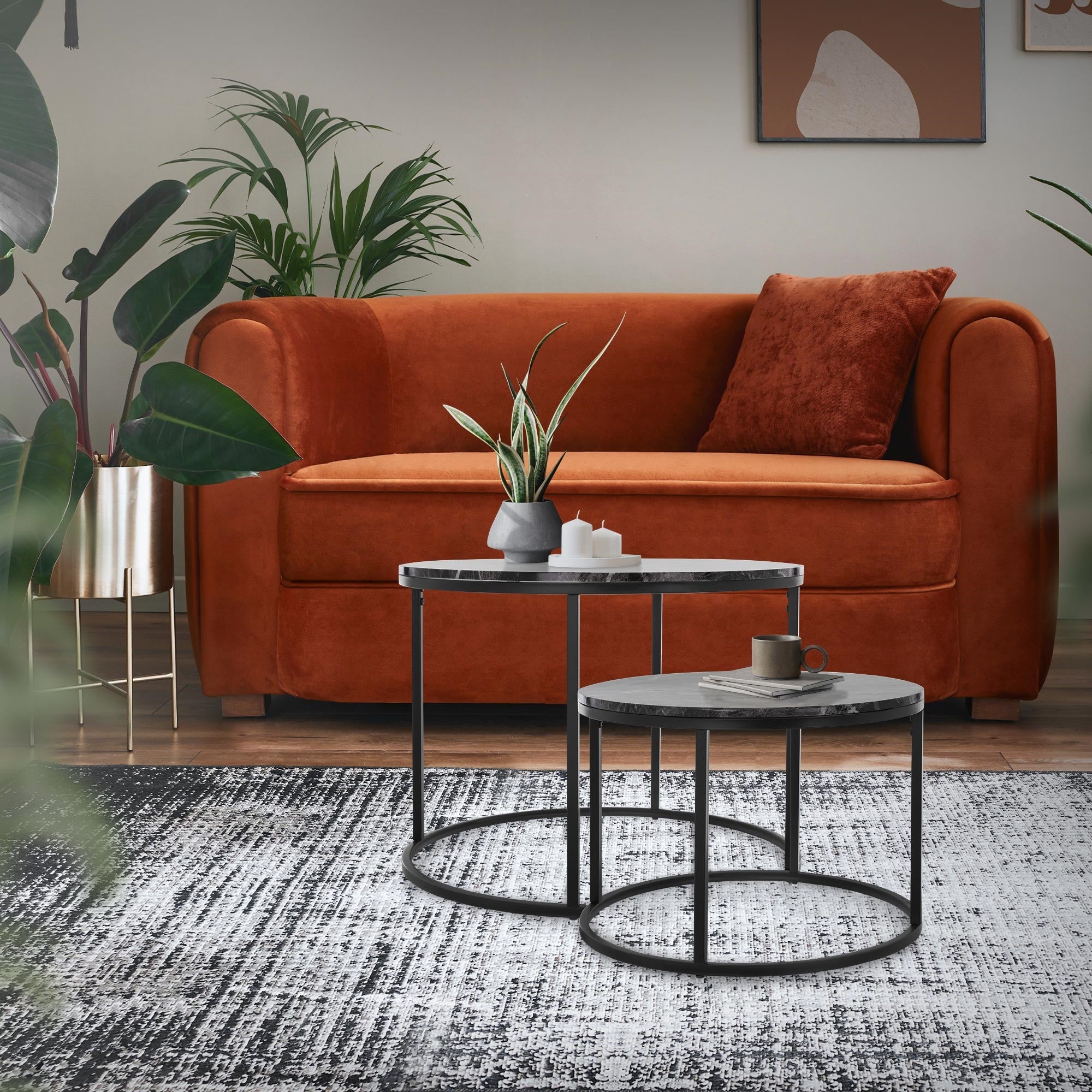 To sideborde i en stue med planter og en sofa.