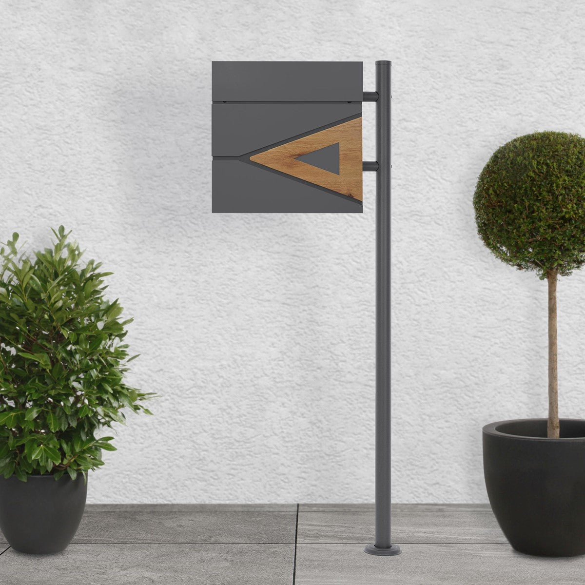 Mailbox on a stand surrounded by plants.