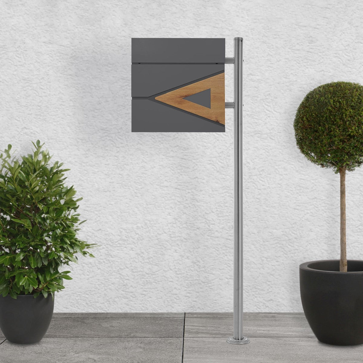 Moderner Paketbriefkasten mit Holzdetails und Pflanzen im Hintergrund.