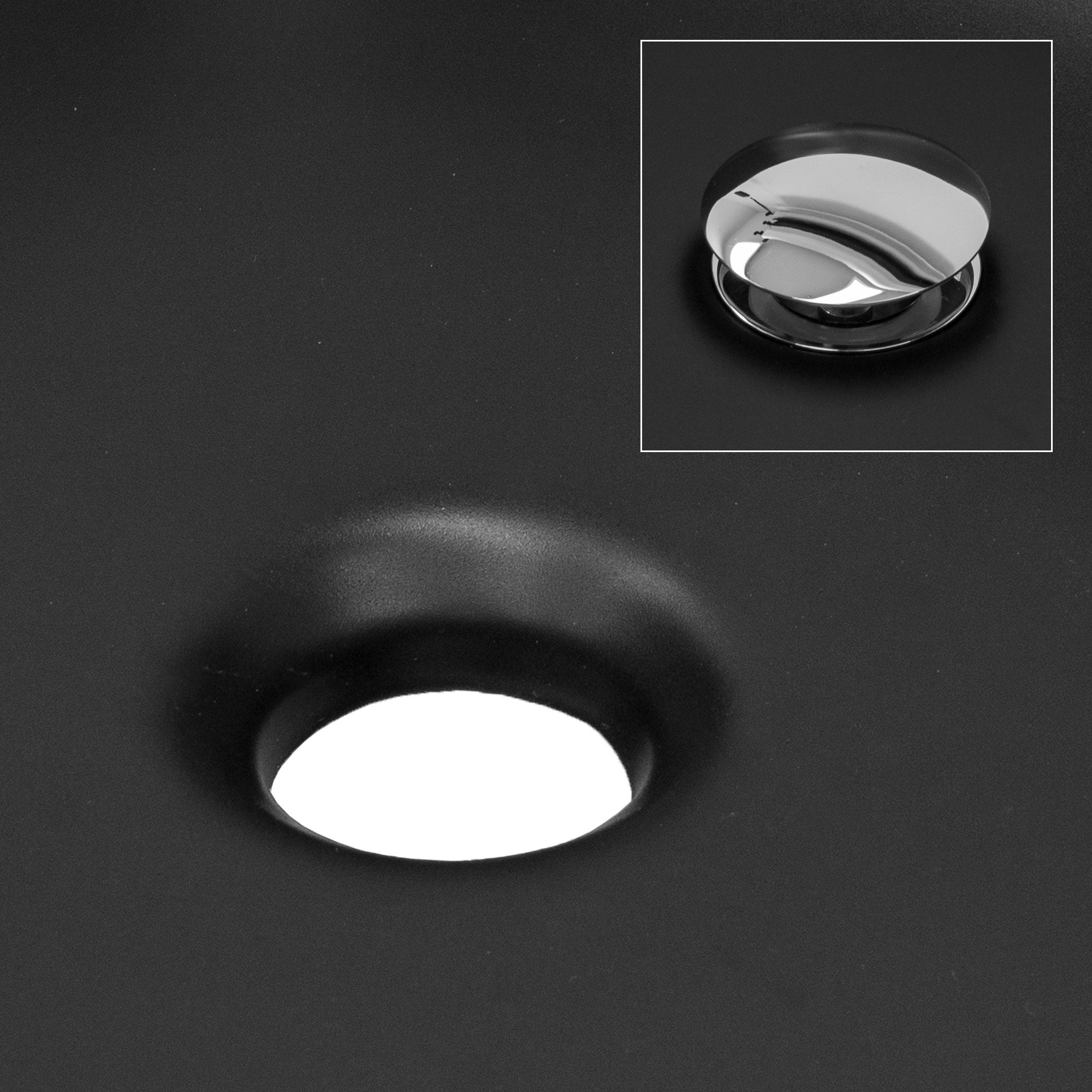 Close-up of the drain hole of a black sink.