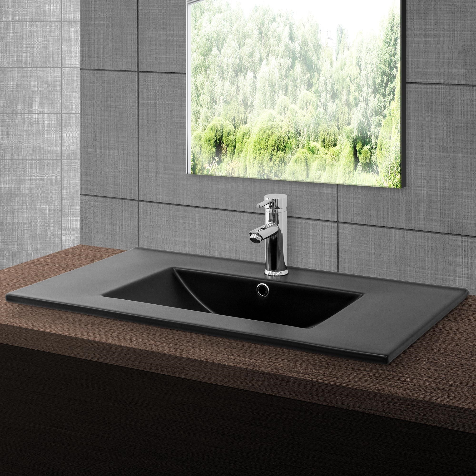 Black sink on a wooden surface with a window in the background.