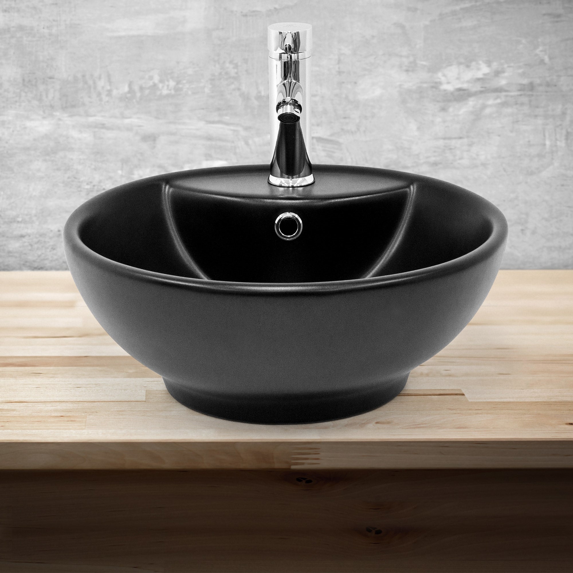 Black sink with a shiny faucet on a wooden surface.