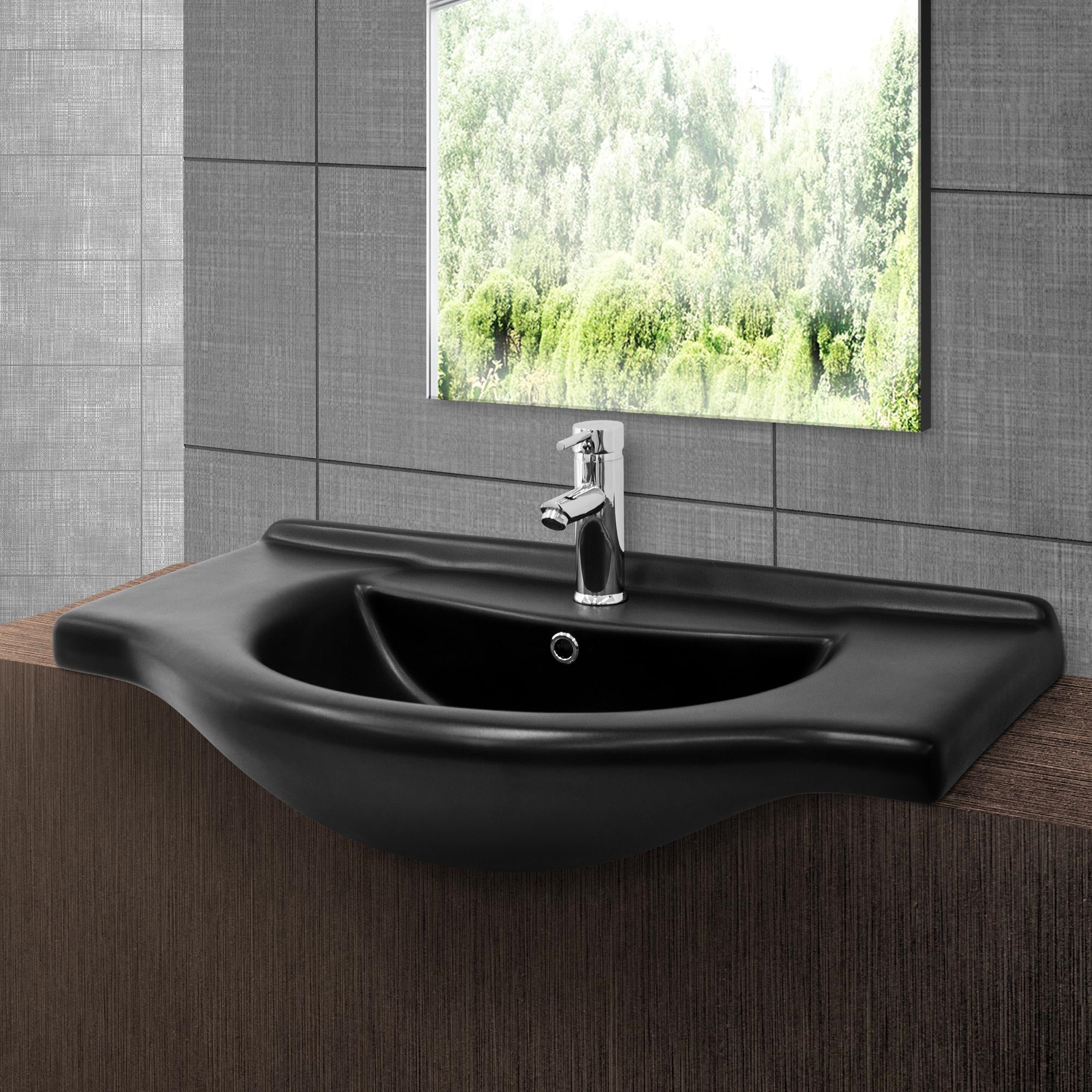 A black sink with faucet and mirror.