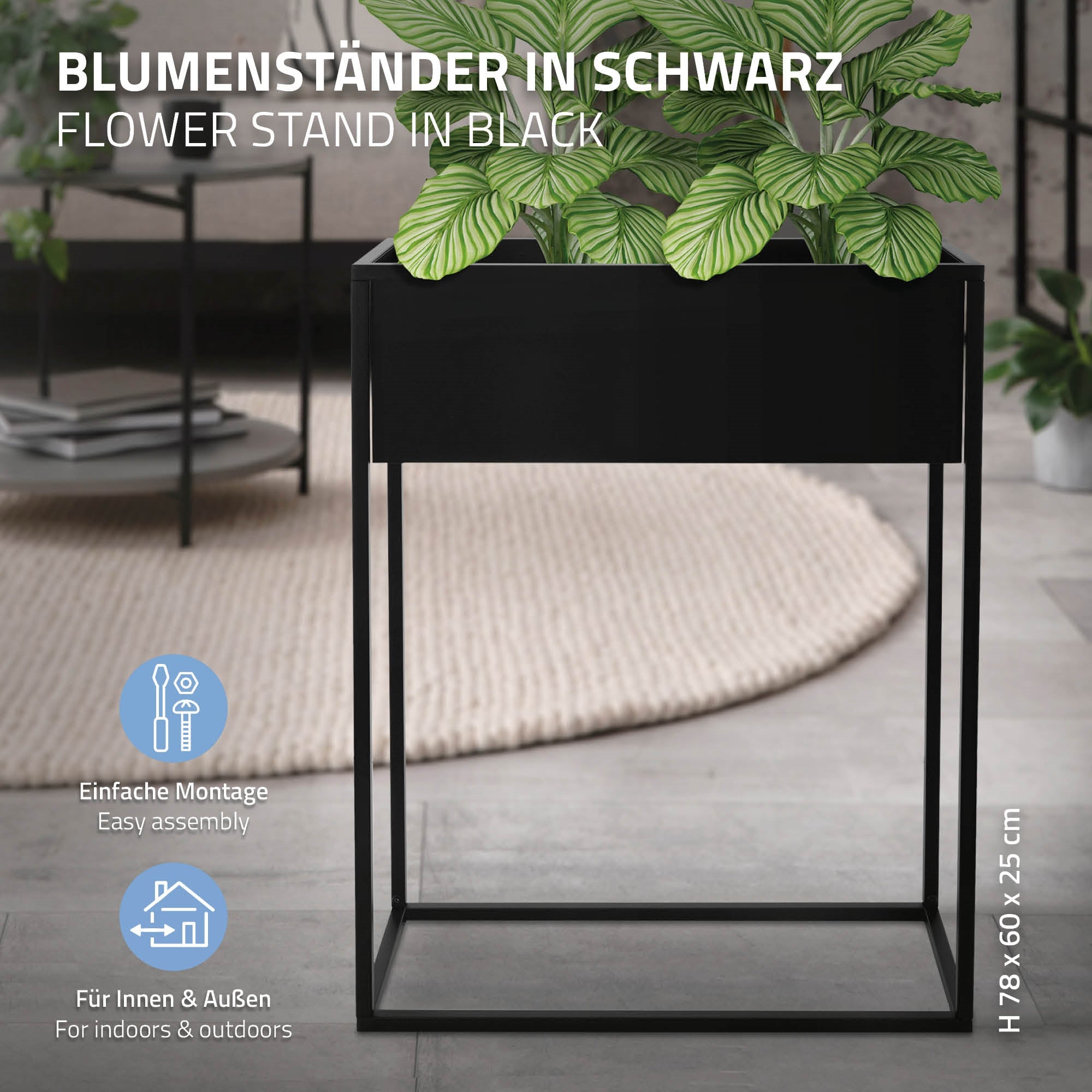 Schwarzer Blumenständer mit Pflanzen, auf einem hellen Boden in einem Raum.