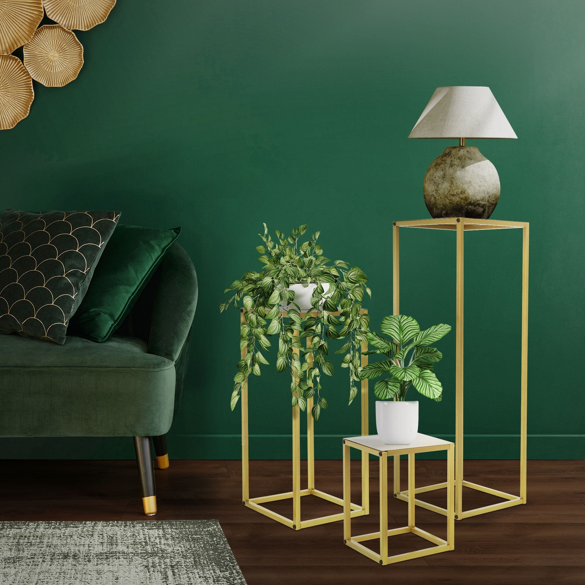Salon avec mur vert, structures de table dorées et plantes.