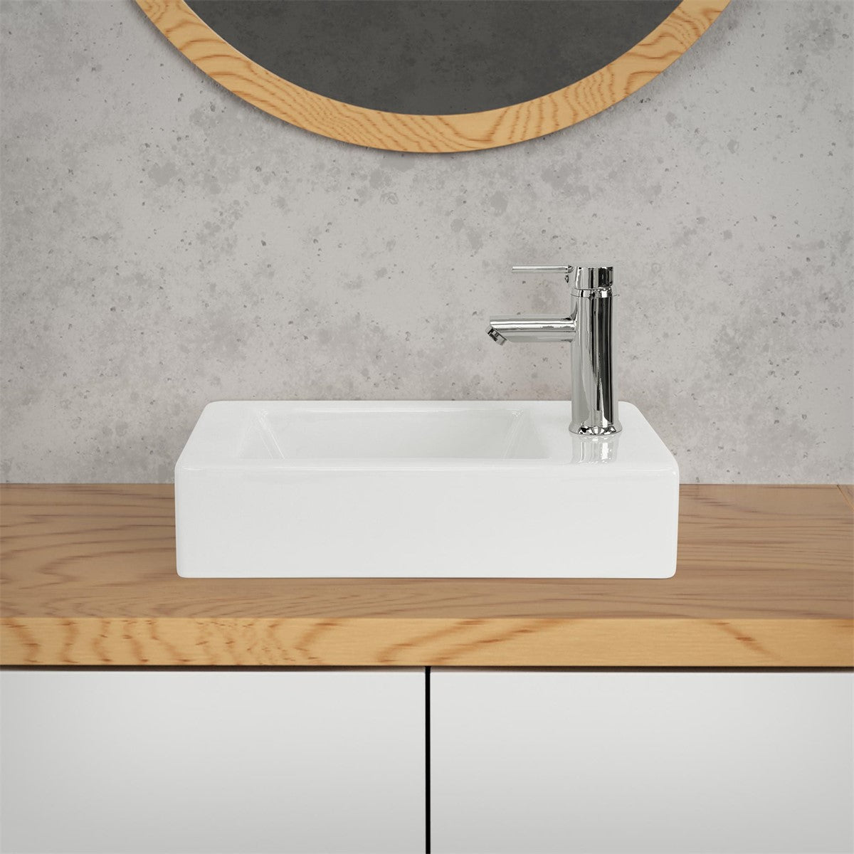 Weißes Waschbecken mit Wasserhahn auf einer Holzoberfläche.