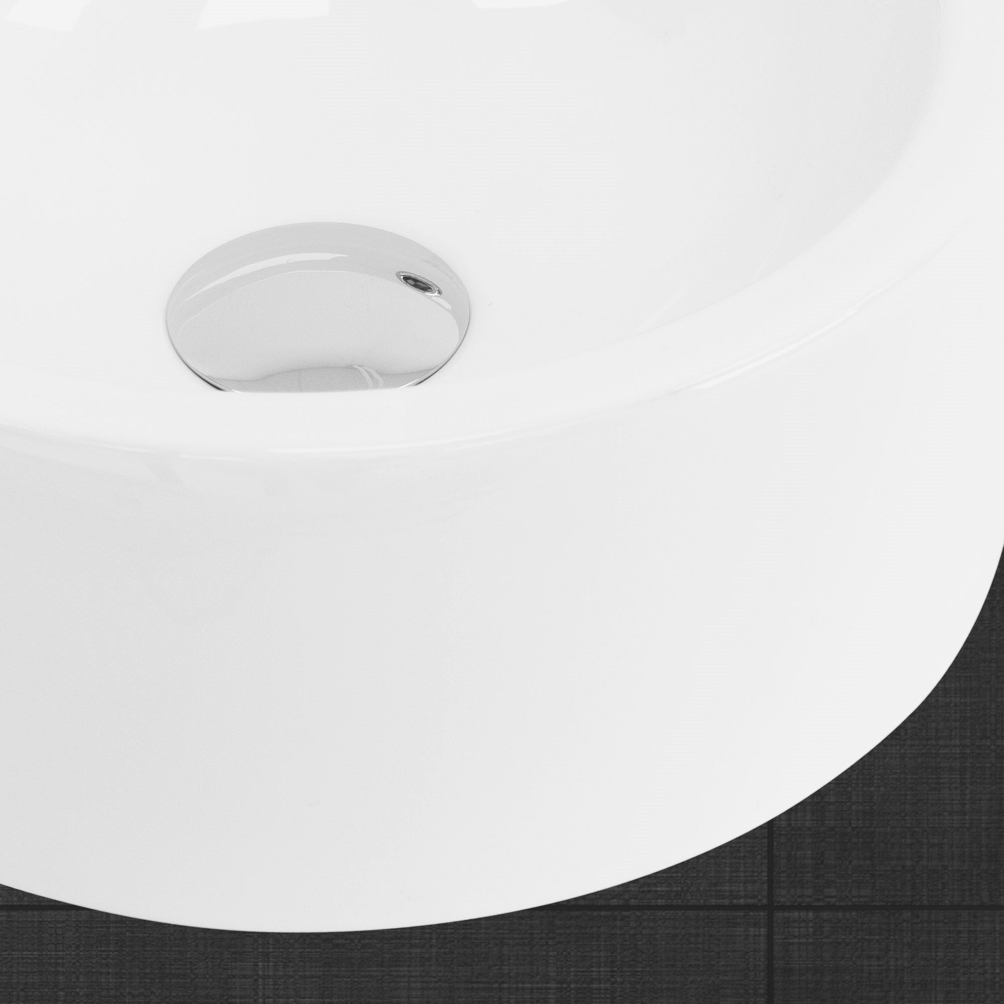 Close-up of a white sink with shiny drain.