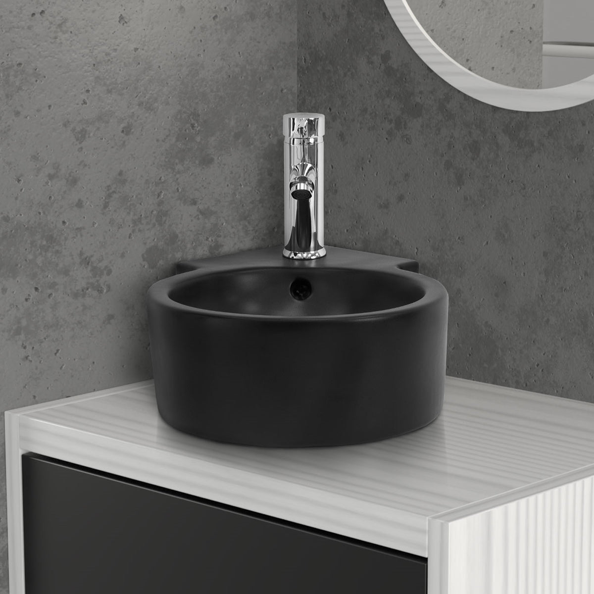 Schwarzes, rundes Waschbecken mit Wasserhahn auf einem Regal.