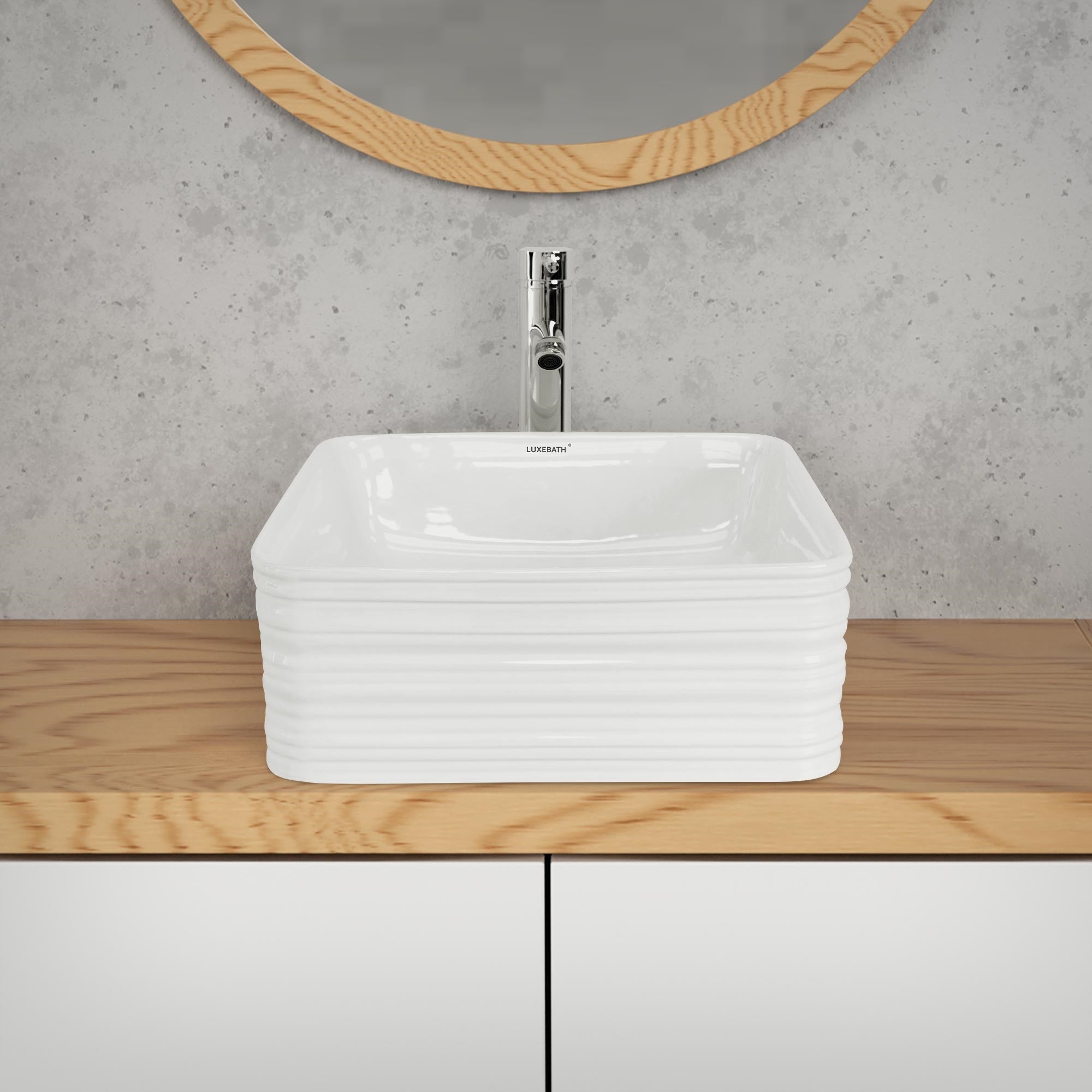 Lavabo blanc sur un meuble en bois avec miroir en arrière-plan.