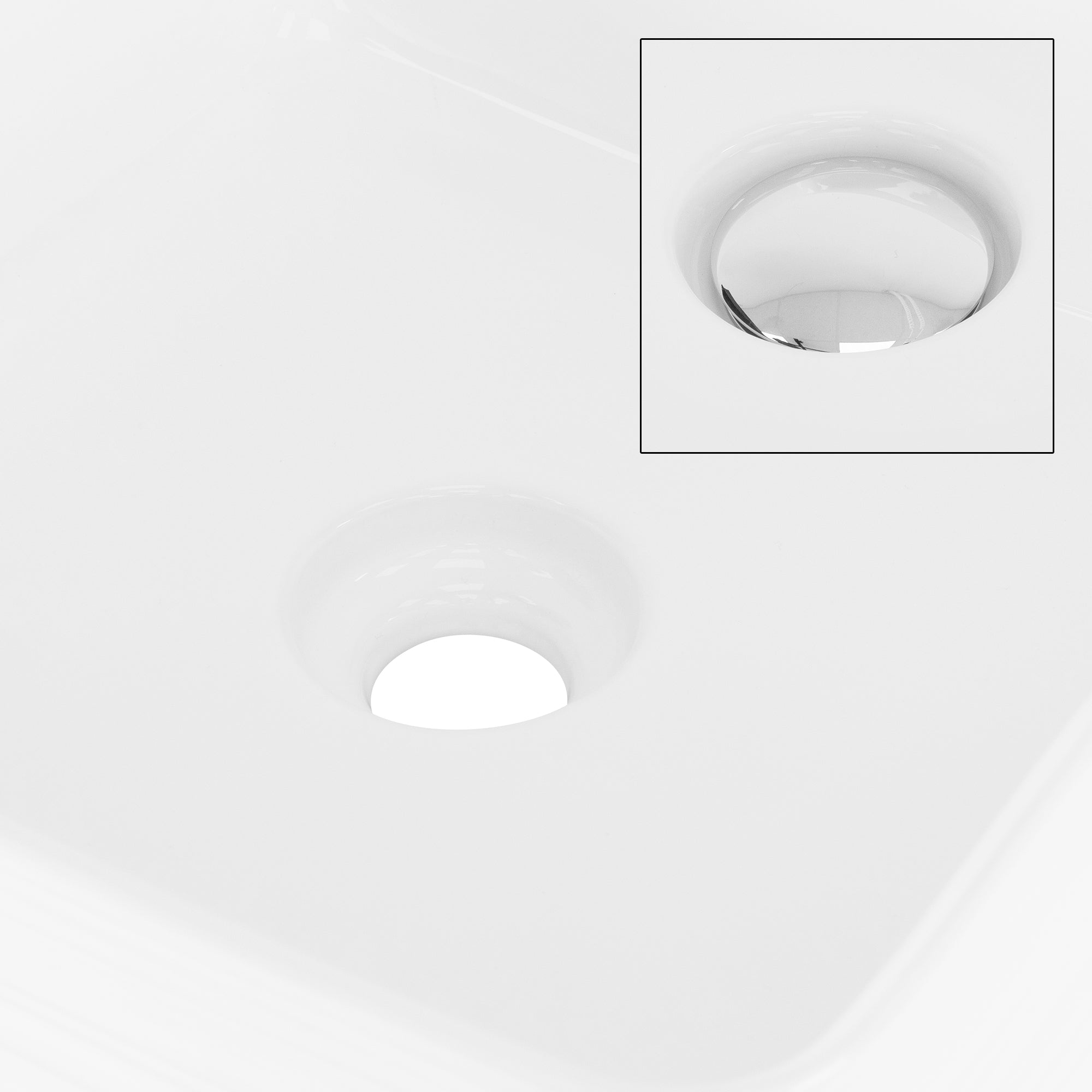 Lavabo blanc avec deux trous d'évacuation, l'un agrandi.