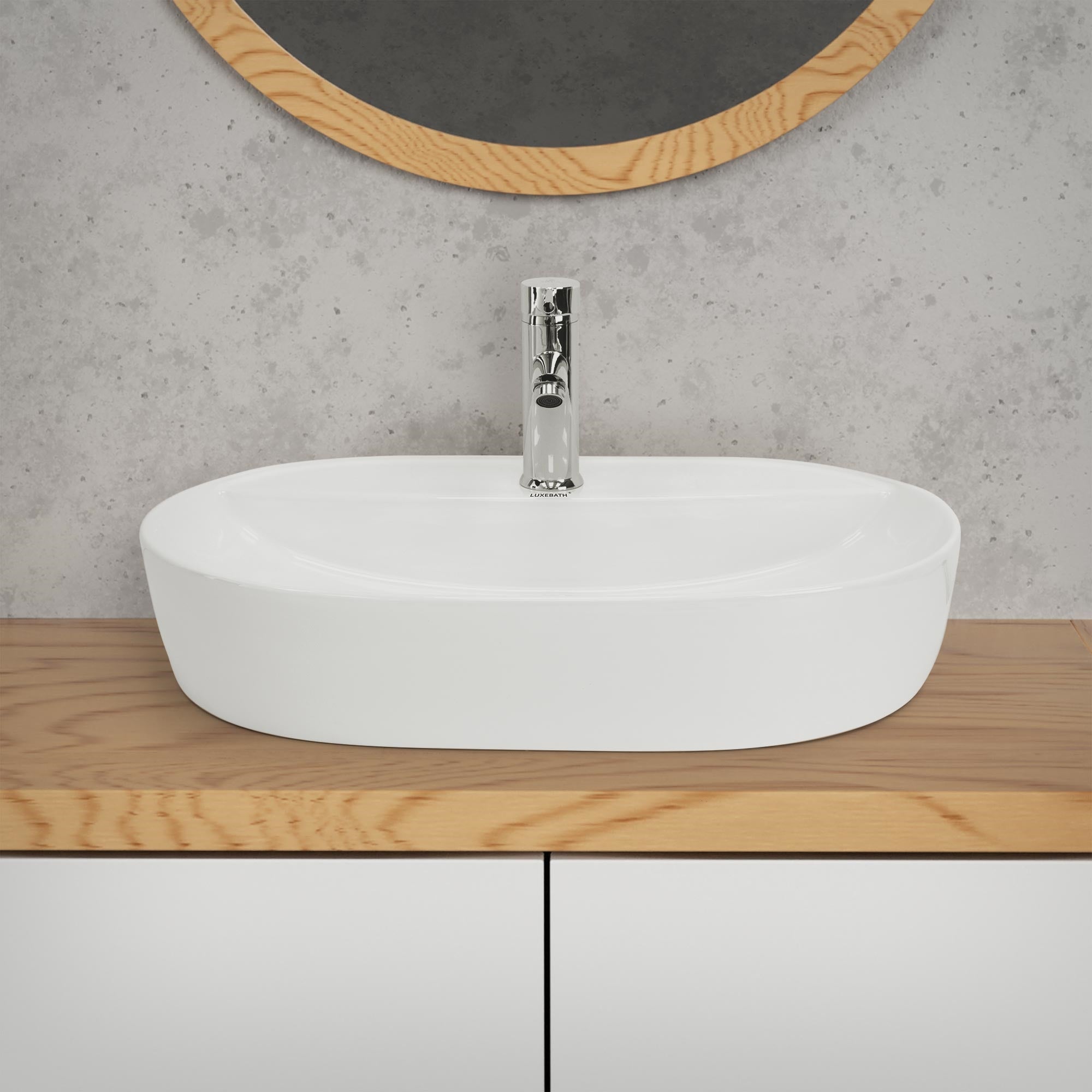 Witte, ovale wastafel op een houten plank met spiegel op de achtergrond.