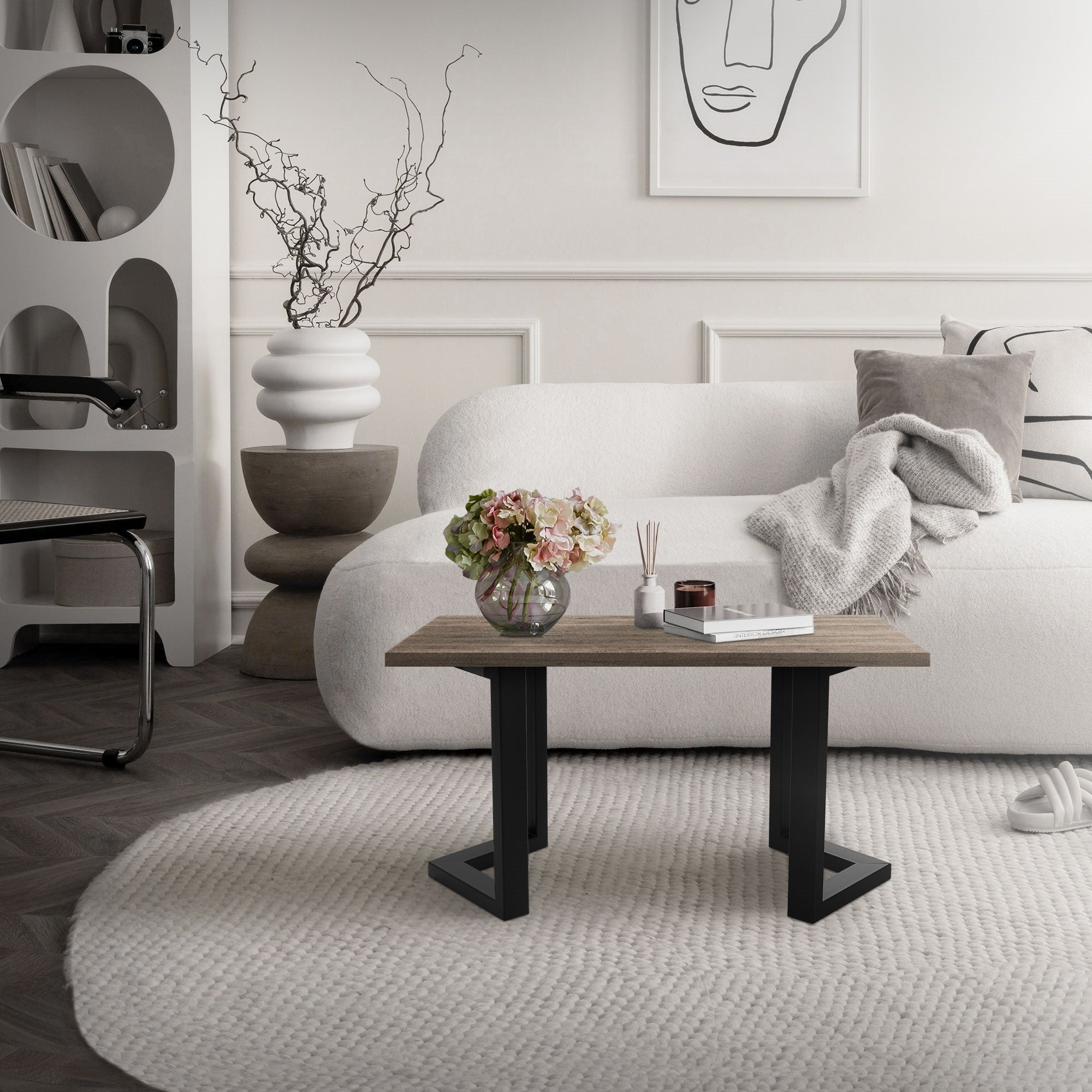 Un soggiorno moderno con un divano bianco, un tavolo in legno e un vaso con fiori.