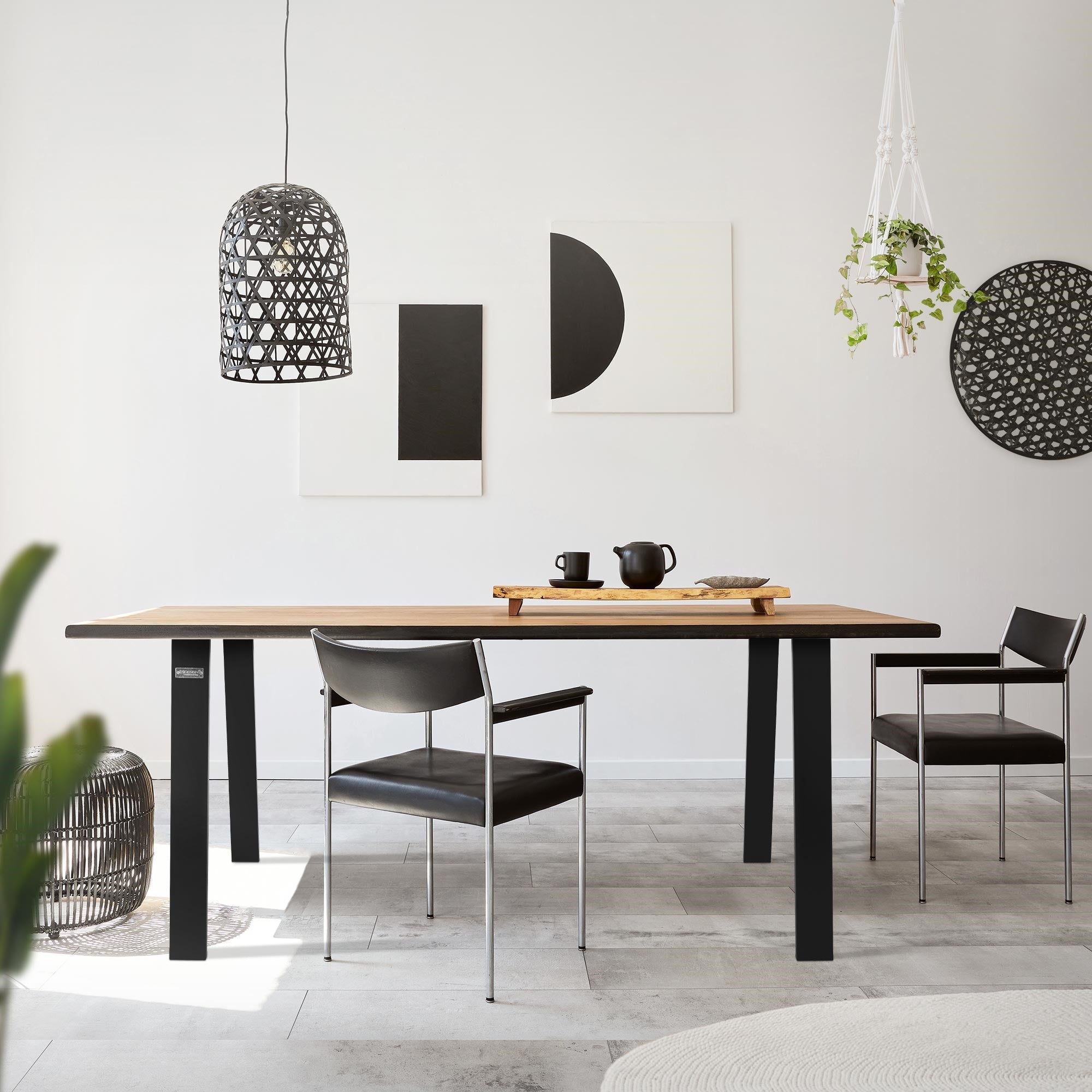 Une table avec deux chaises dans une pièce lumineuse, décorée de plantes et de tableaux.