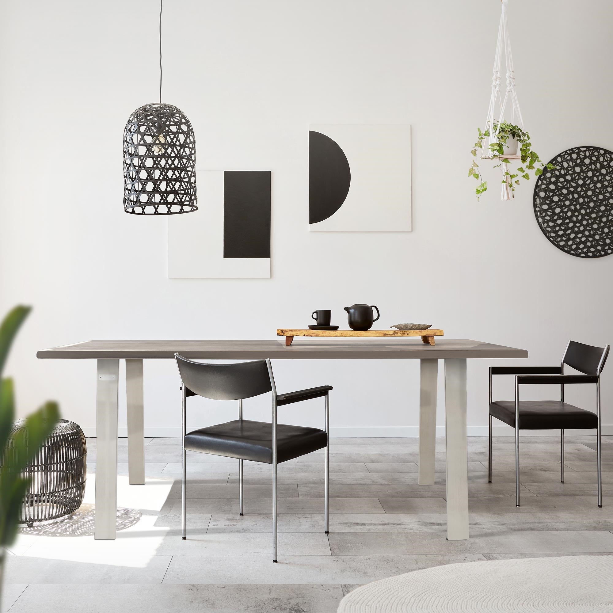 Essbereich mit Tisch, Stühlen und dekorativen Wandbildern.