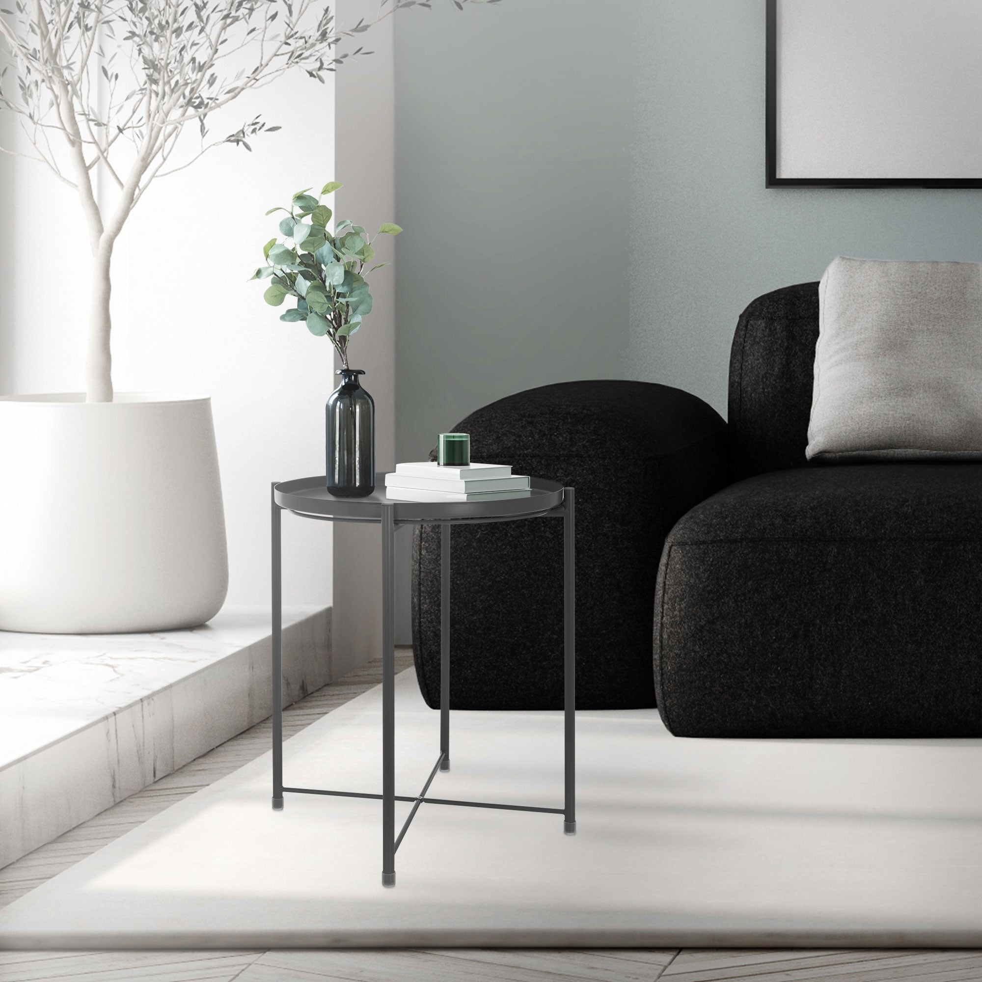 Bord i et rum, ved siden af en sofa, med planter og dekoration.