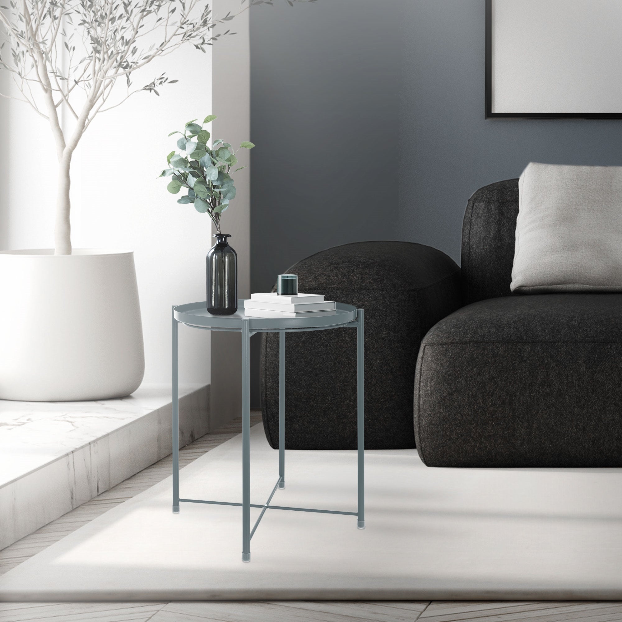 Ein runder Glastisch neben einem schwarzen Sofa in einem modernen Raum.