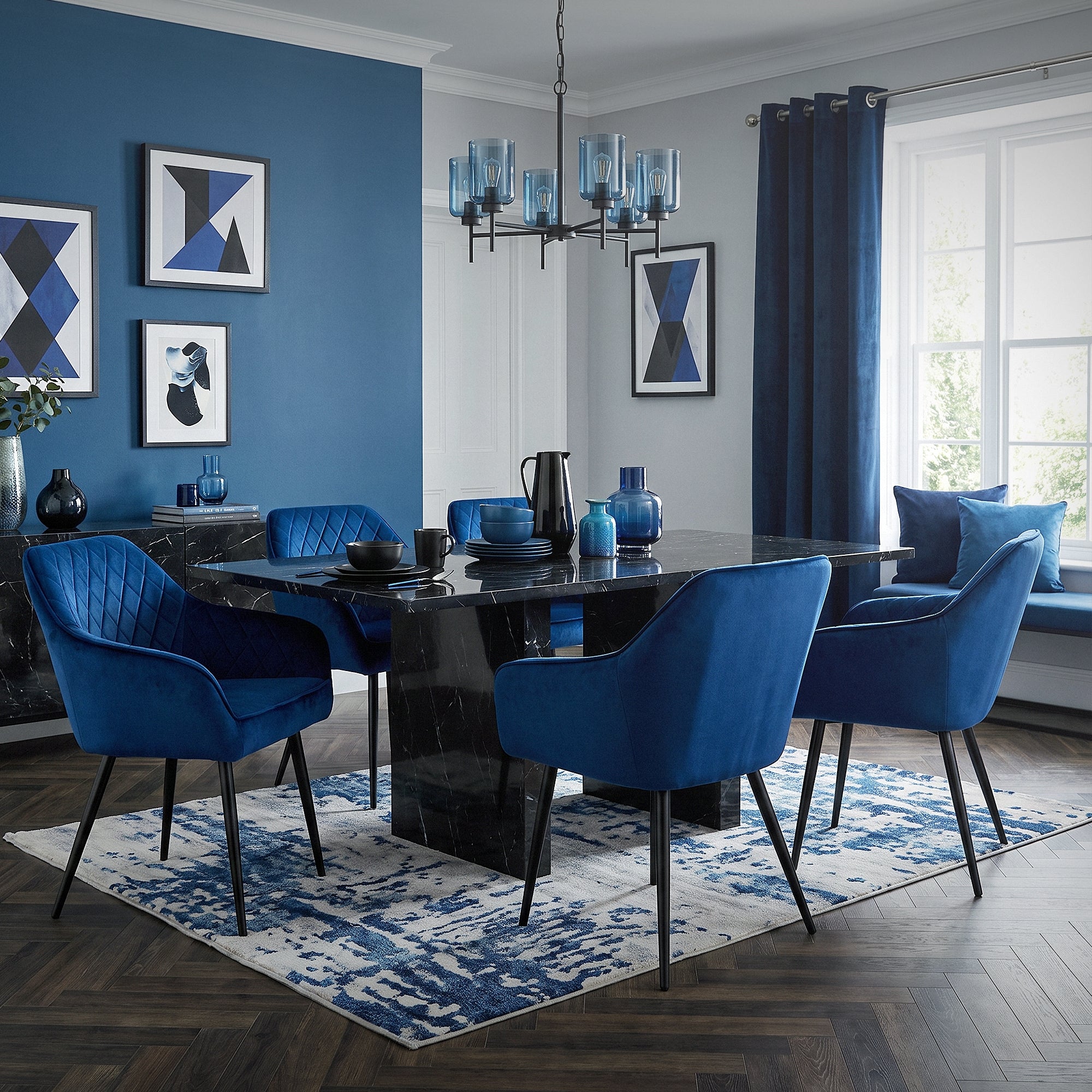 Esszimmer mit blauen Stühlen, Tisch und dekorativen Elementen an der Wand.
