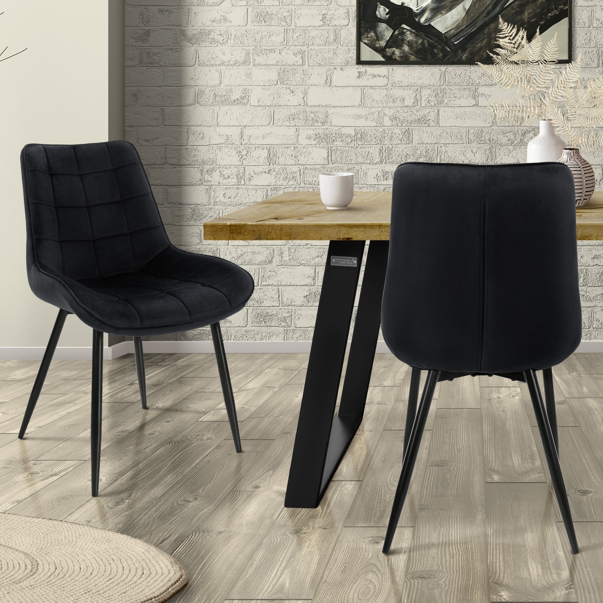 Zwei schwarze Stühle an einem Tisch vor einer gemusterten Wand.