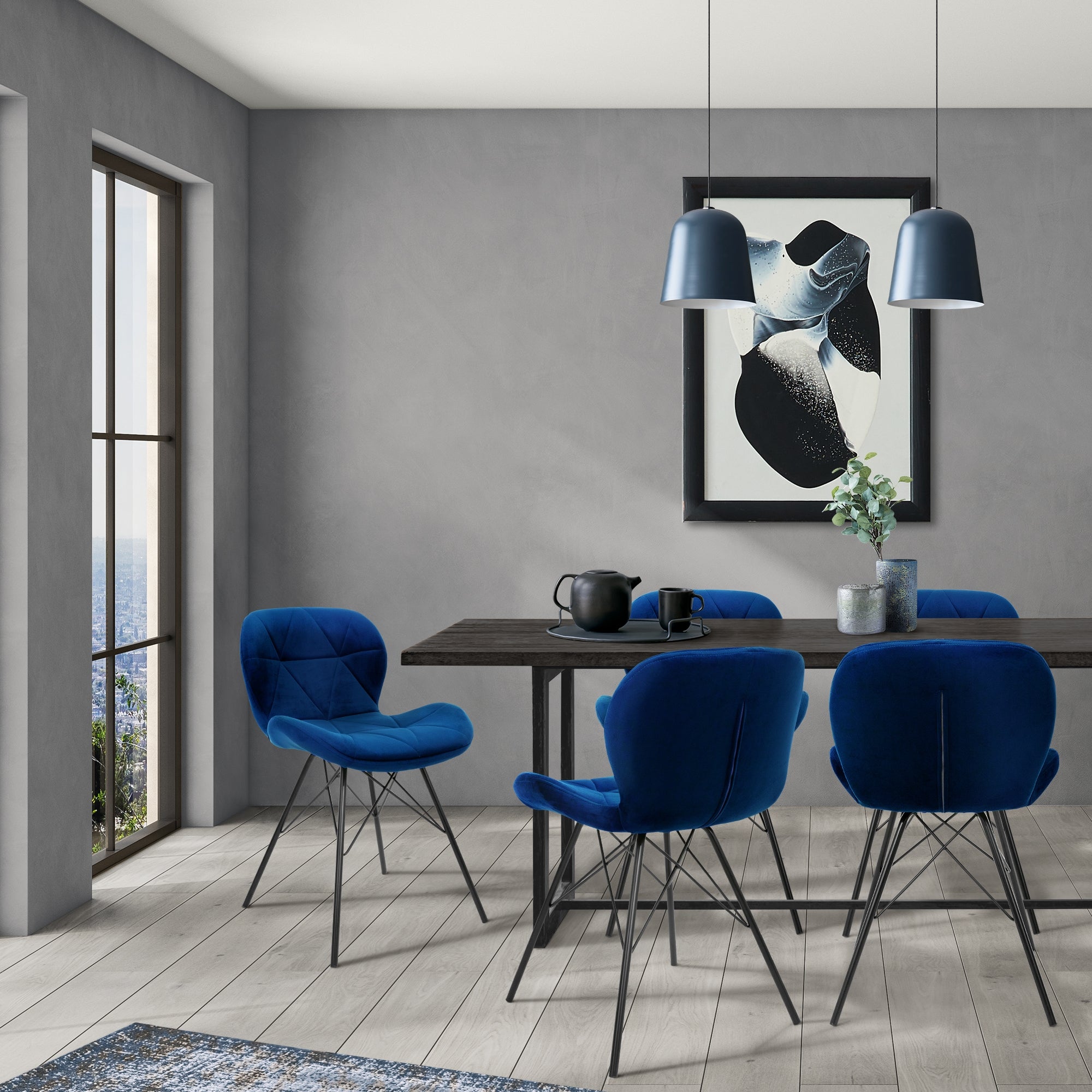 Quattro sedie blu attorno a un tavolo in una stanza moderna con finestra e opere d'arte.