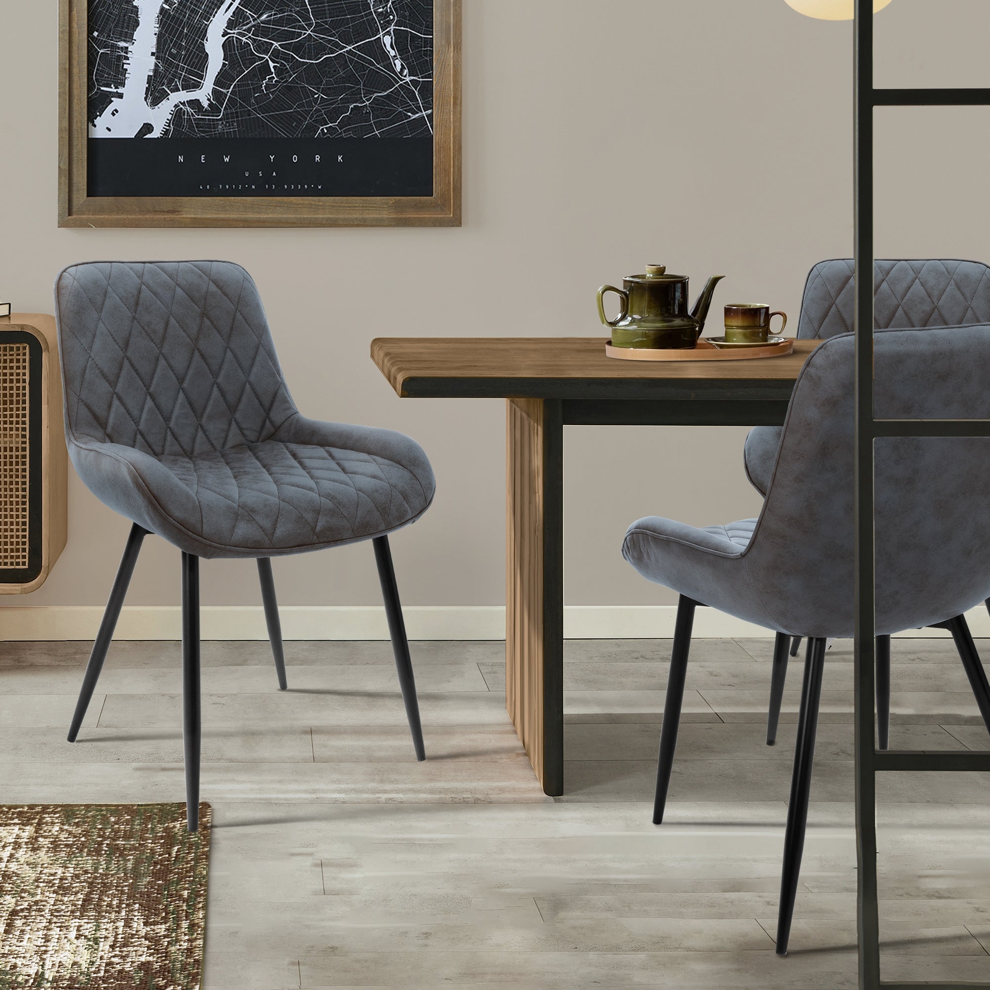 Esszimmer mit einem Tisch und grauen gepolsterten Stühlen.