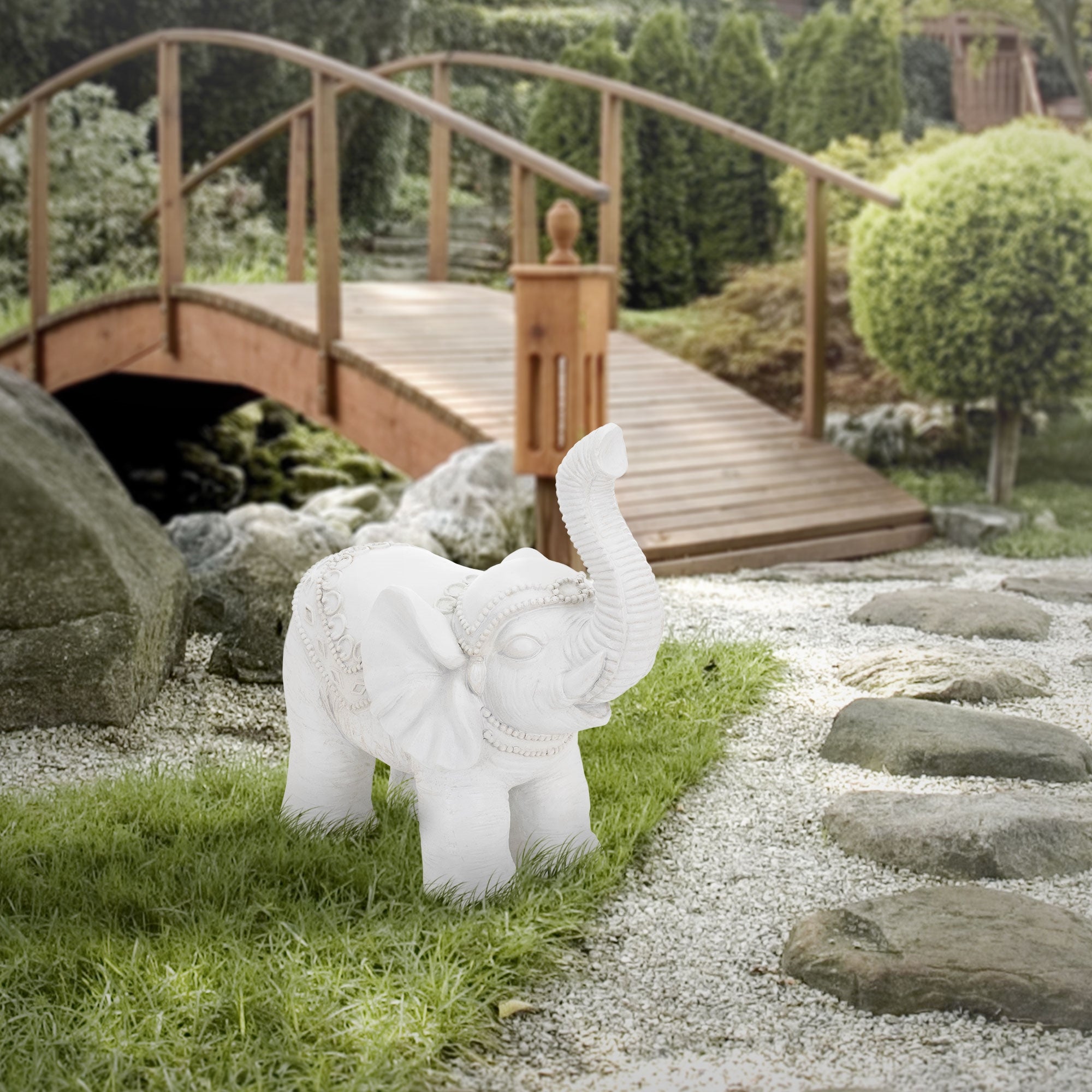 Der gleiche Elefant auf einem Weg, mit einer Holzbrücke im Hintergrund.