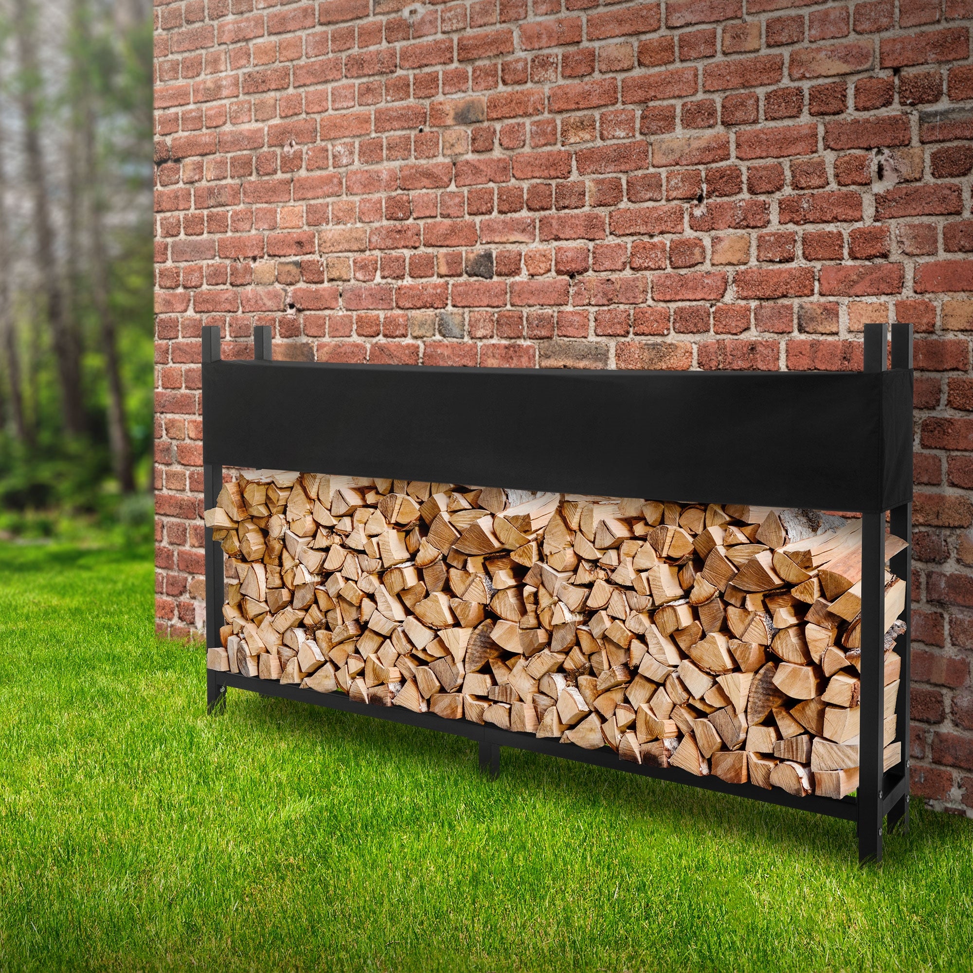 Ein Holzlager aus Holzscheiten vor einer Backsteinmauer auf grünem Rasen.