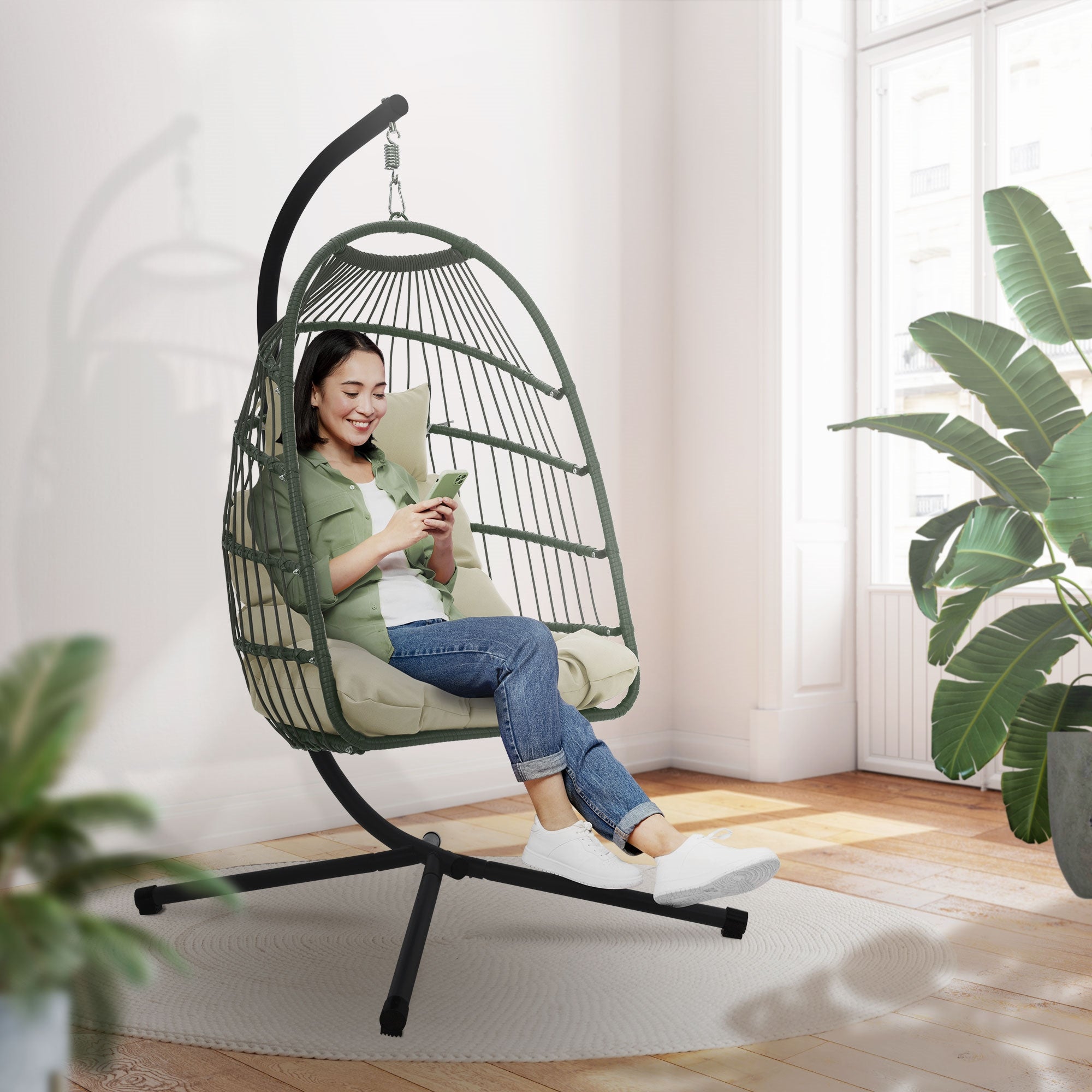 Personne assise dans un fauteuil suspendu et utilisant un smartphone.