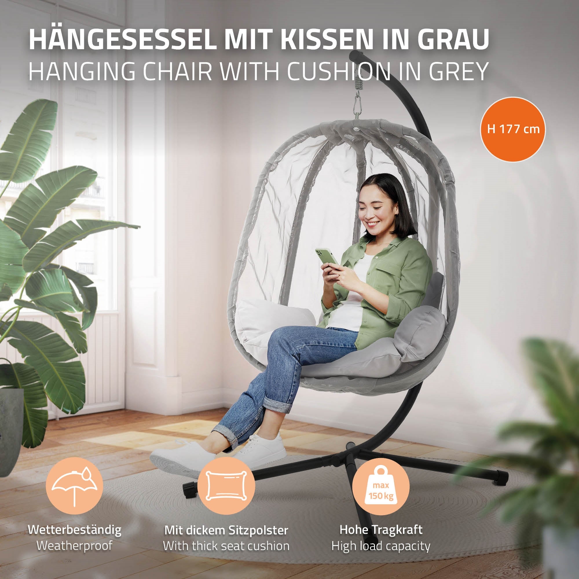 Hængekøje i grå, med en person der sidder med telefonen, i et lyst rum.