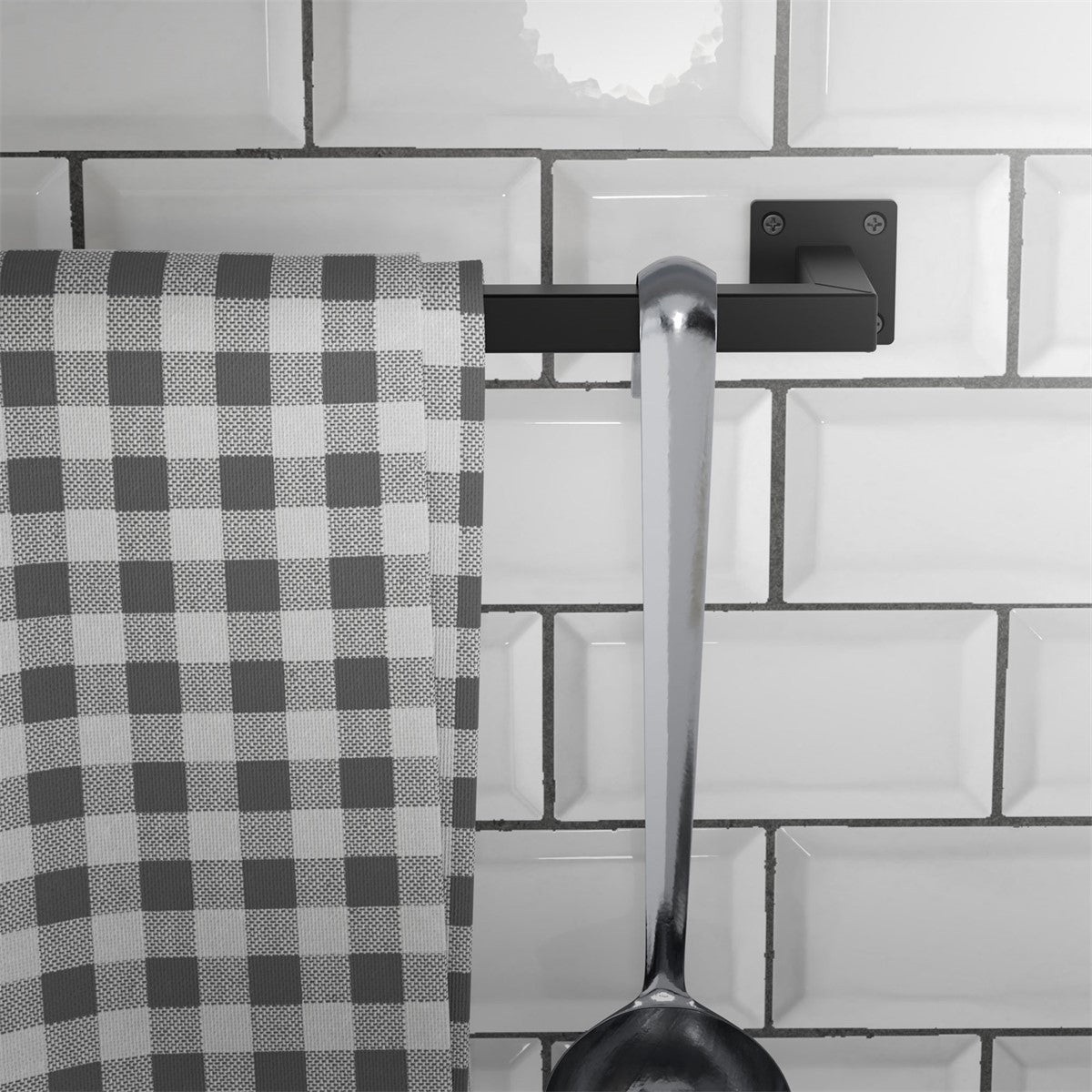Un canovaccio è appeso a un supporto nero accanto a un grande cucchiaio.