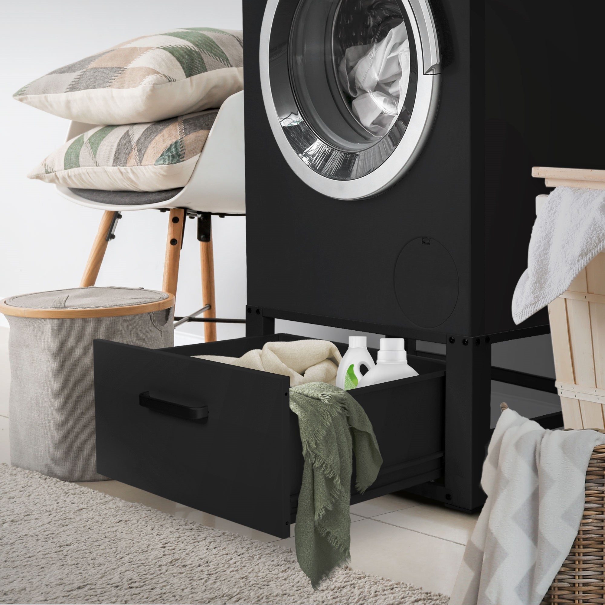 Boîte de rangement noire à côté d'un lave-linge dans une pièce.