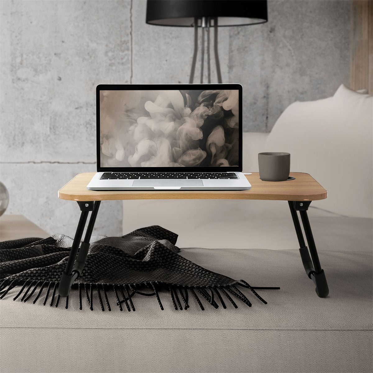 Laptop egy fatálcán, egy csészével és egy takaróval.