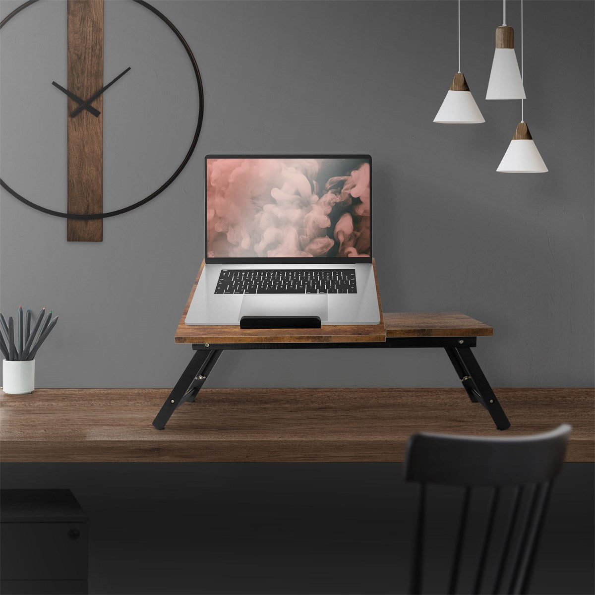 Holztisch mit Laptop, dekoriert mit einer Uhr und Pendelleuchten.