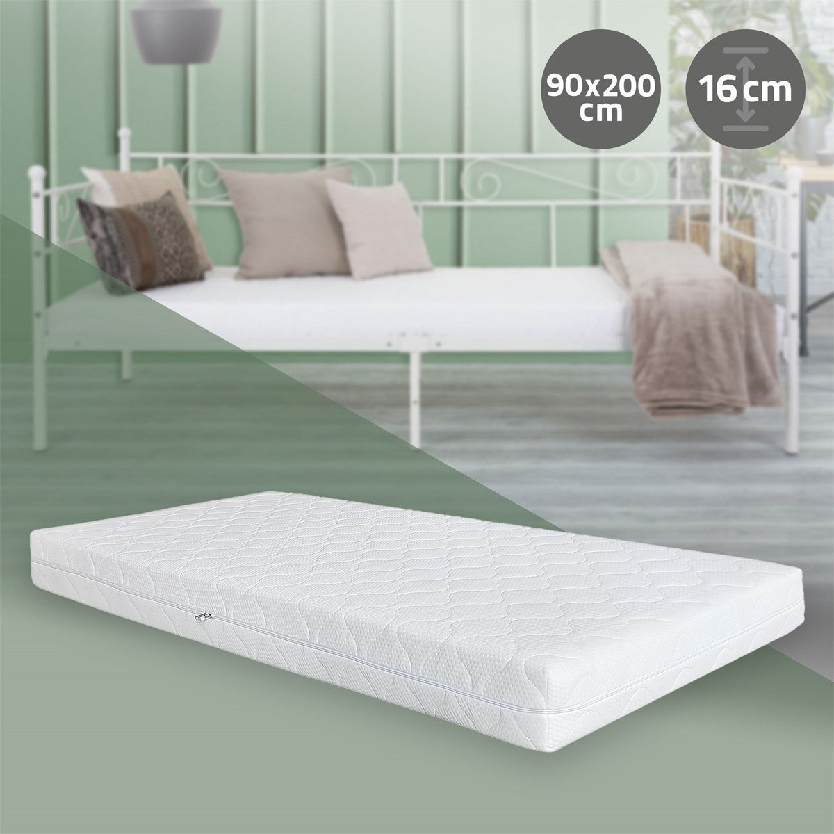 Eine Matratze auf einem Bett mit Kissen und Decke, grüne Wand im Hintergrund.