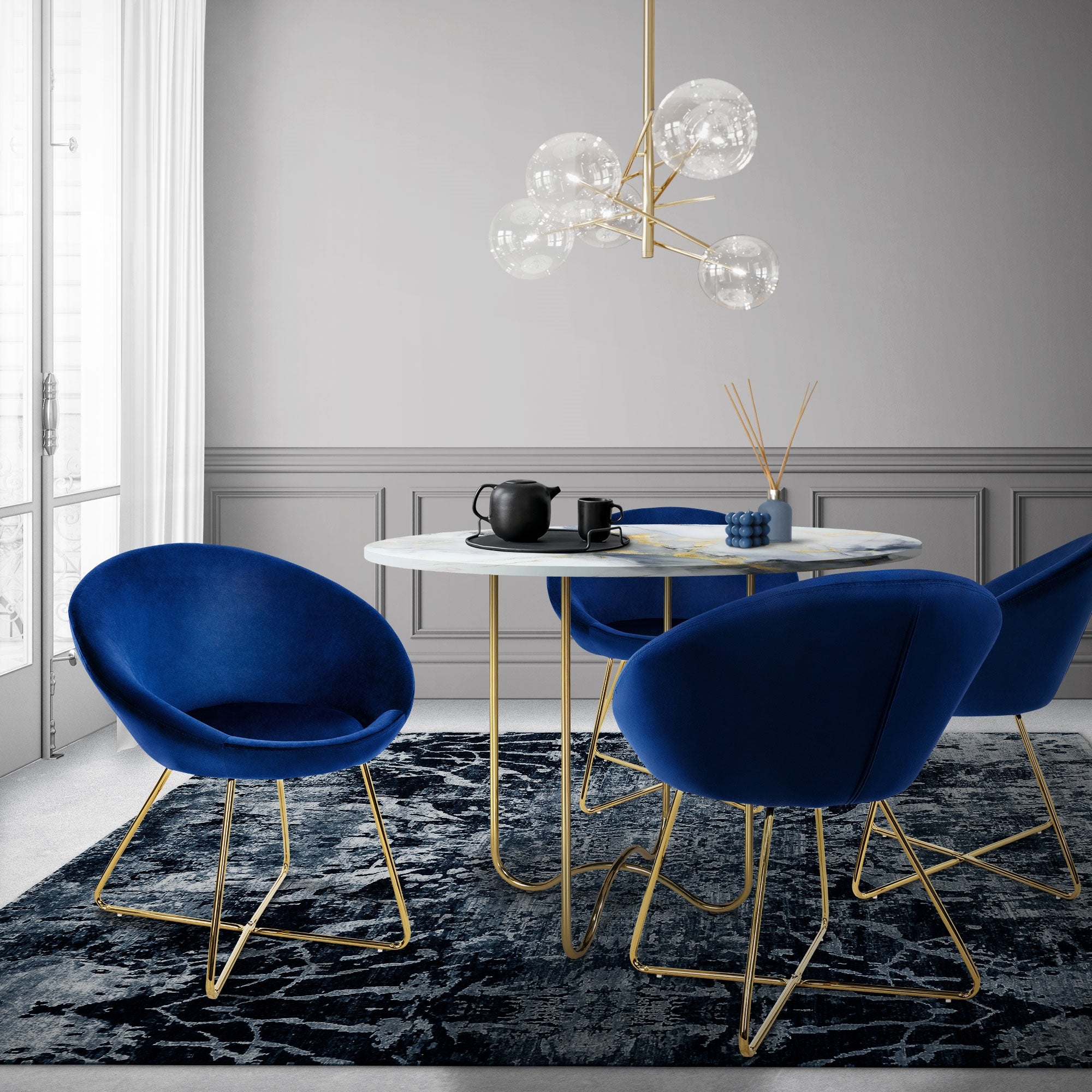 Essbereich mit blauem Sessel, Tisch und Pendelleuchte in modernem Raum.