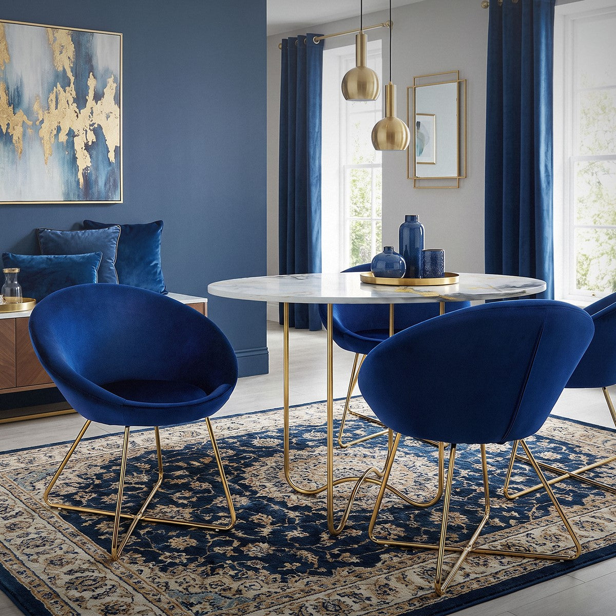 Ein runder Tisch mit vier blauen Stühlen in einem eleganten Raum.