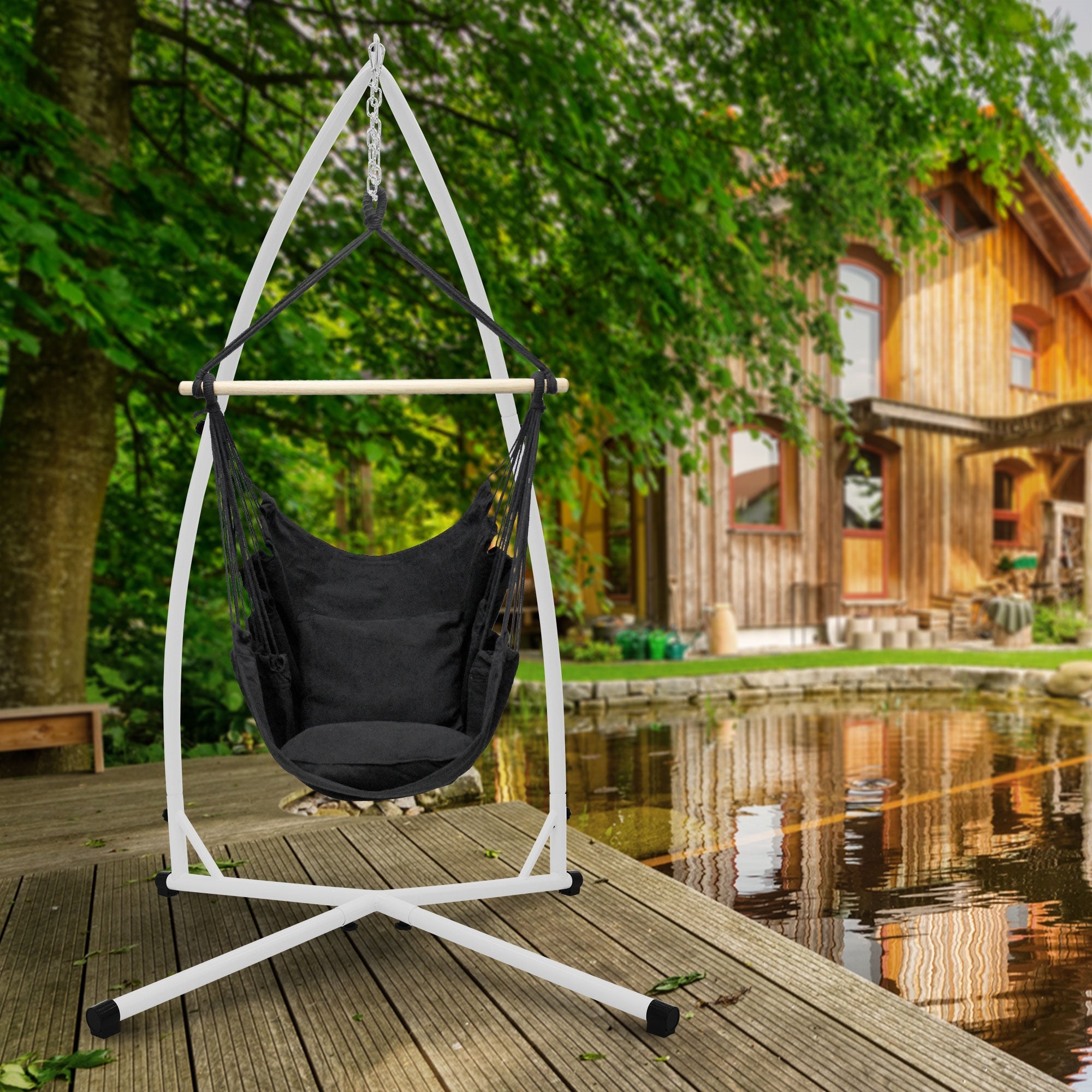 Hängesessel auf einer Terrasse, umgeben von Bäumen und einem Holzhaus im Hintergrund.