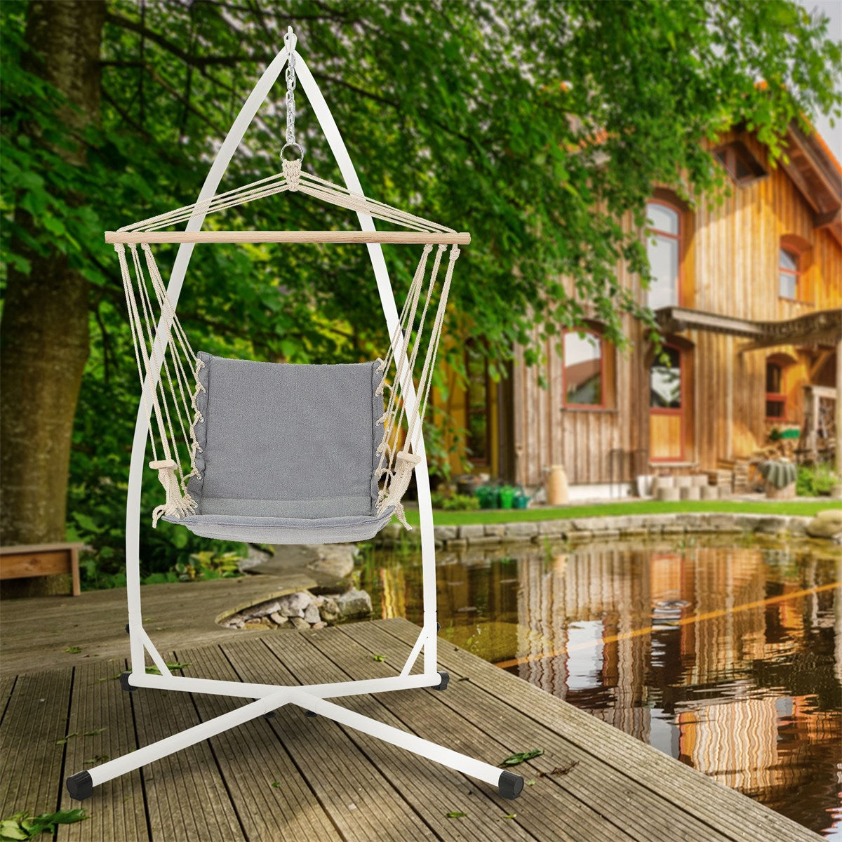 Hängesessel in Grau, auf einer Holzterrasse vor einem Holzhaus.