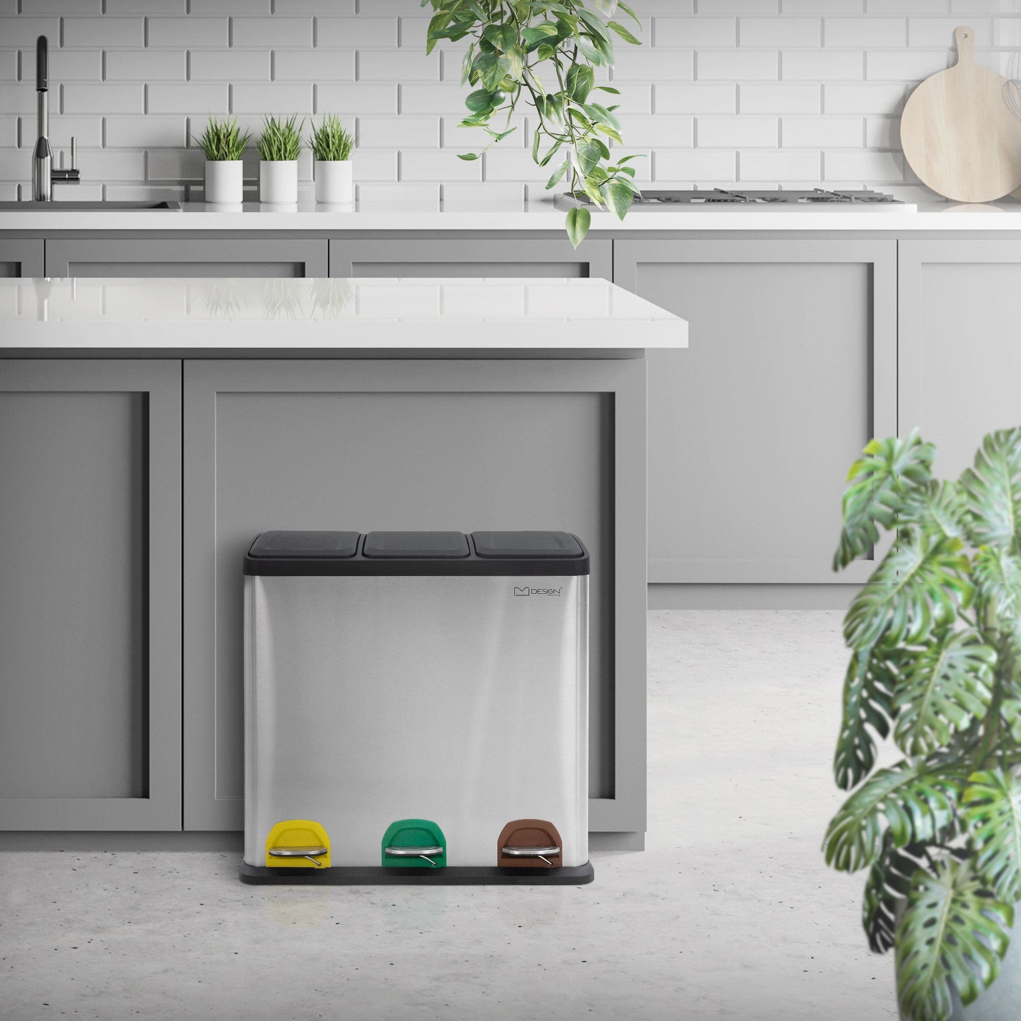 Rozsdamentes acél szemetes három rekesszel és lábpedálokkal egy modern konyhában.