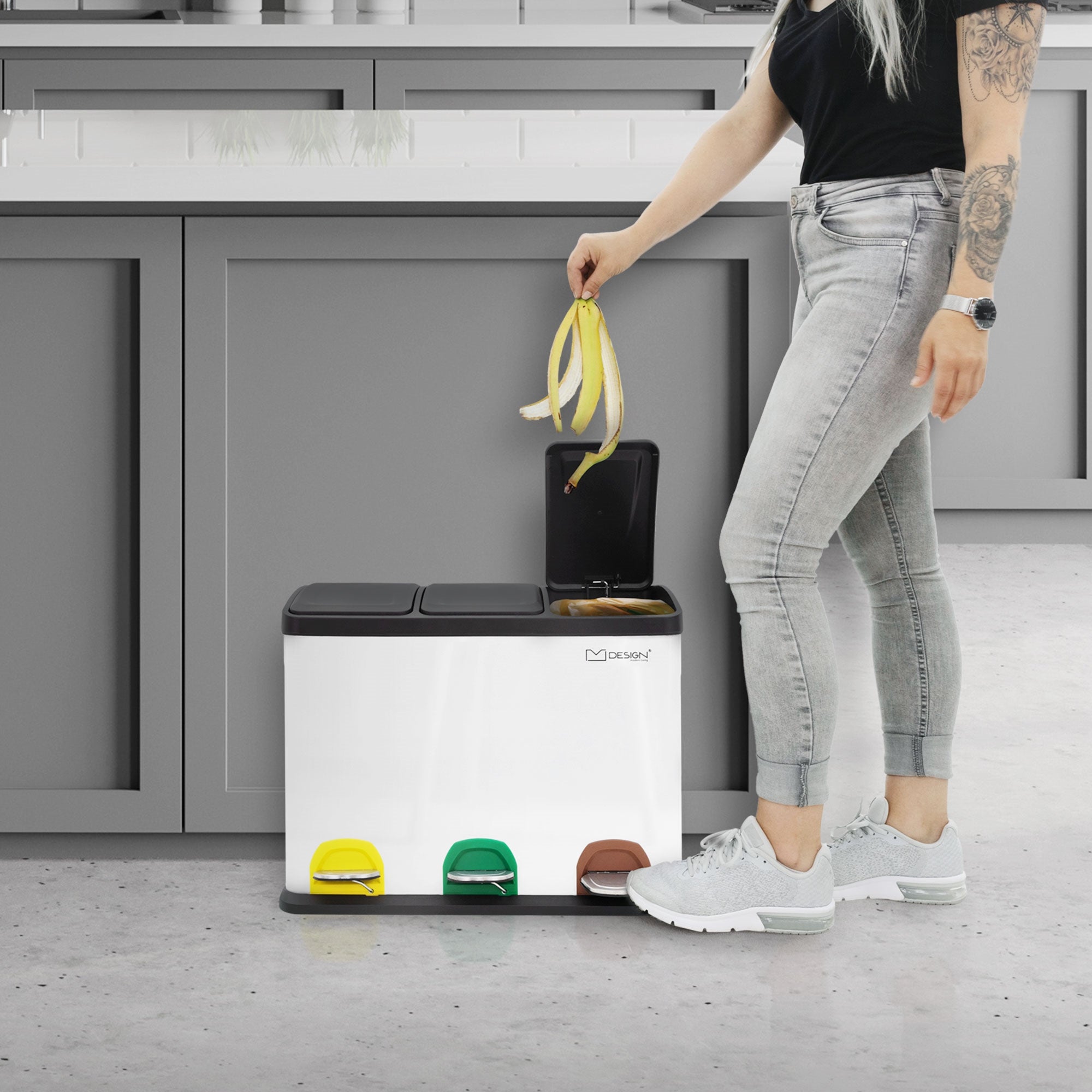 Person steht neben Mülleimer mit Trennsystem, hält eine Banane.