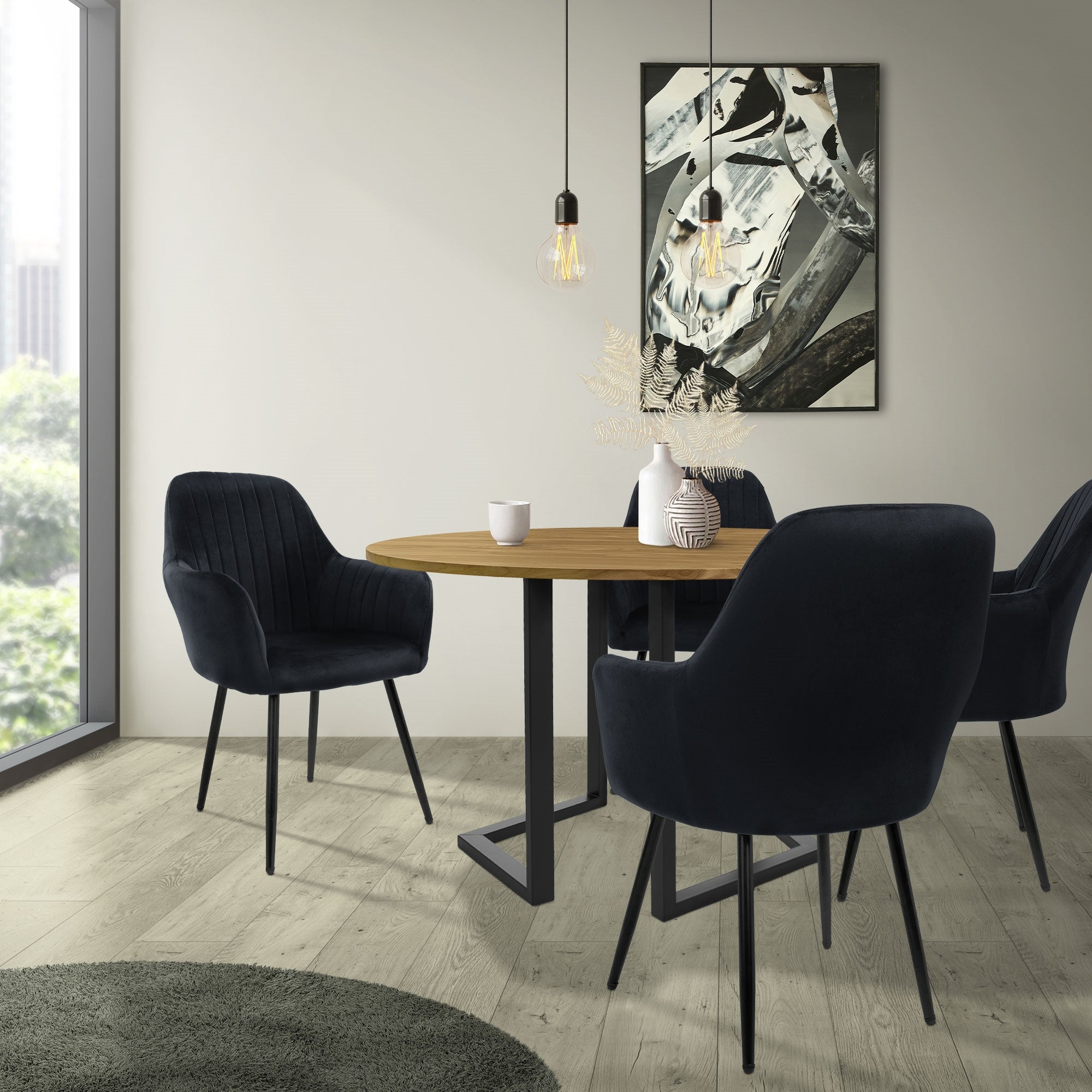 Un'area pranzo moderna con un tavolo rotondo e quattro sedie nere.