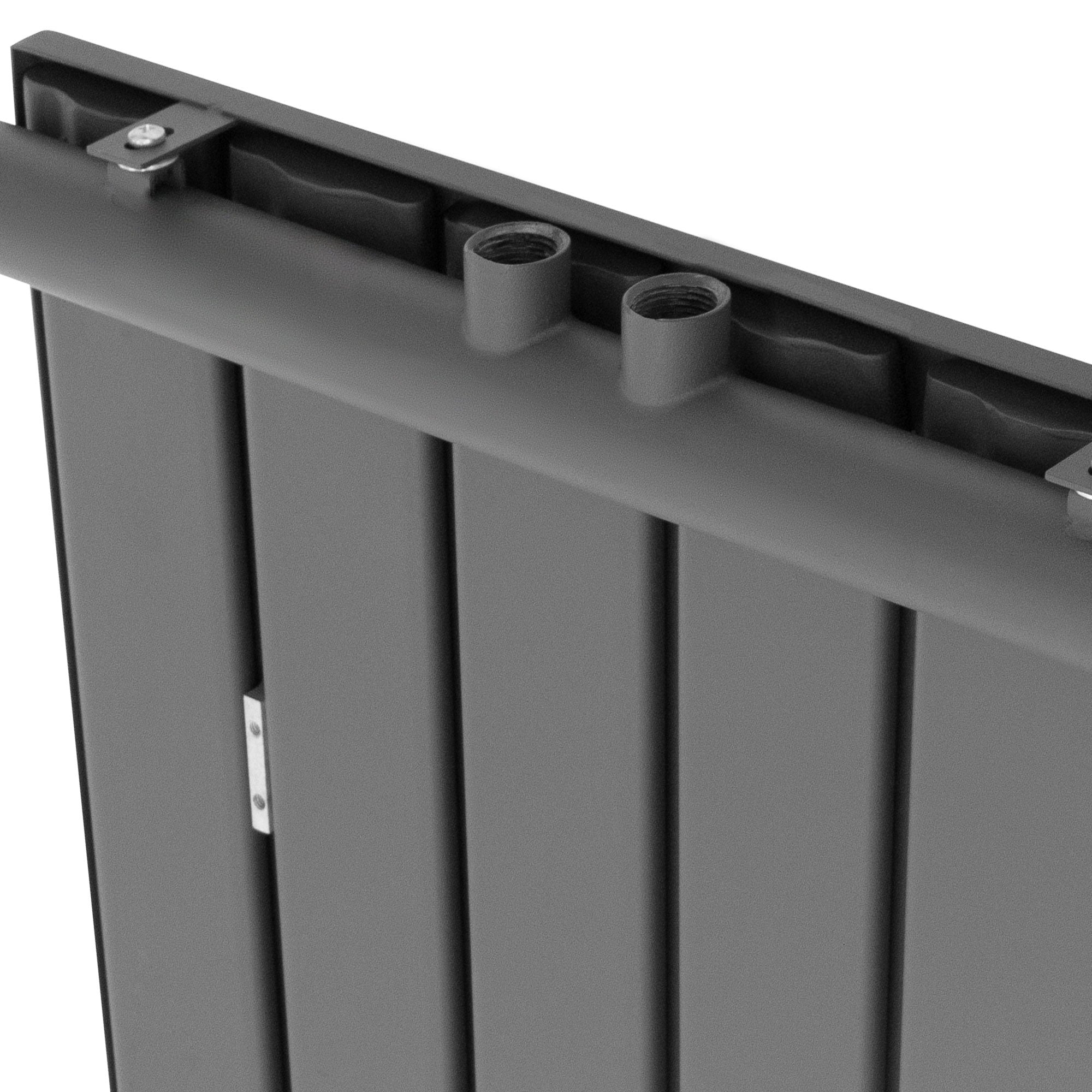 Detailansicht eines anthrazitfarbenen Heizkörpers mit mehreren Rohren.