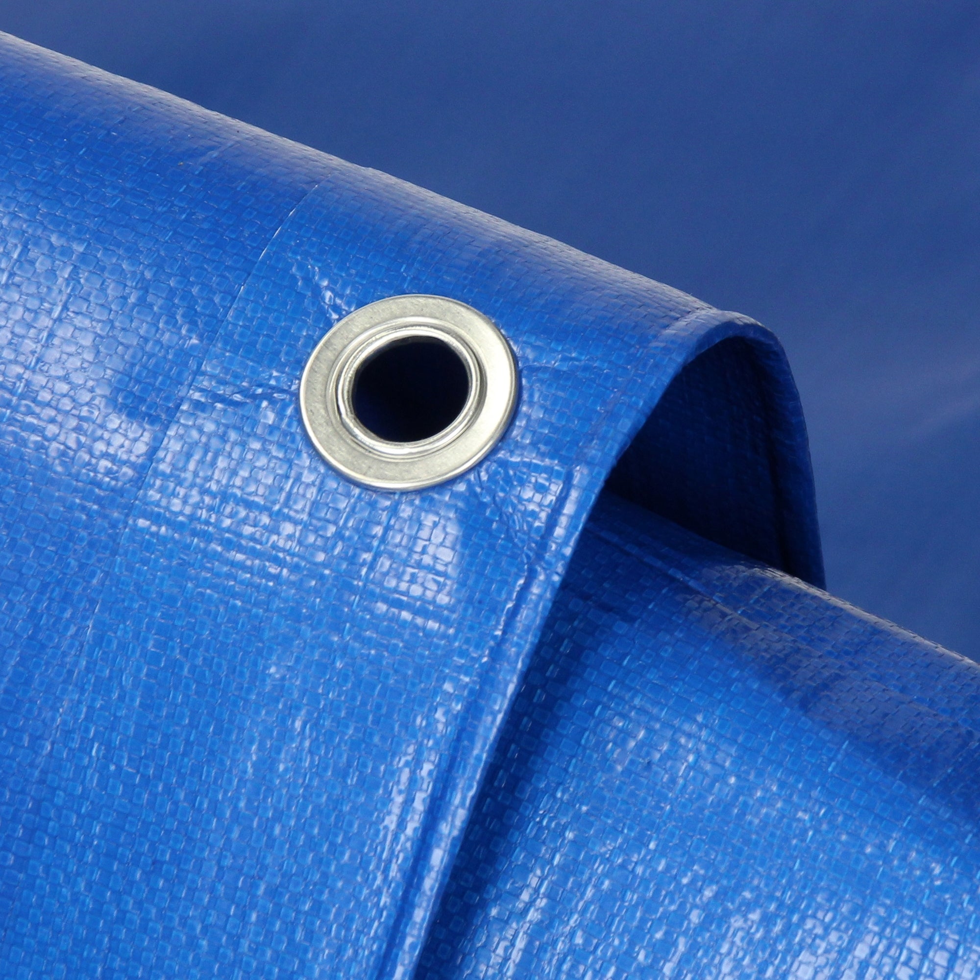 Detailaufnahme einer blauen Plane mit einem Ösenloch.