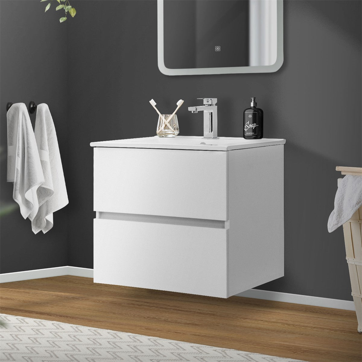 Weißer Waschbeckenunterschrank mit zwei Schubladen und Spiegel an der Wand.