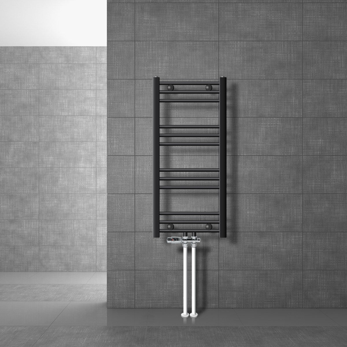 Zwarte handdoekradiator met zichtbare leidingen aan een grijze muur.