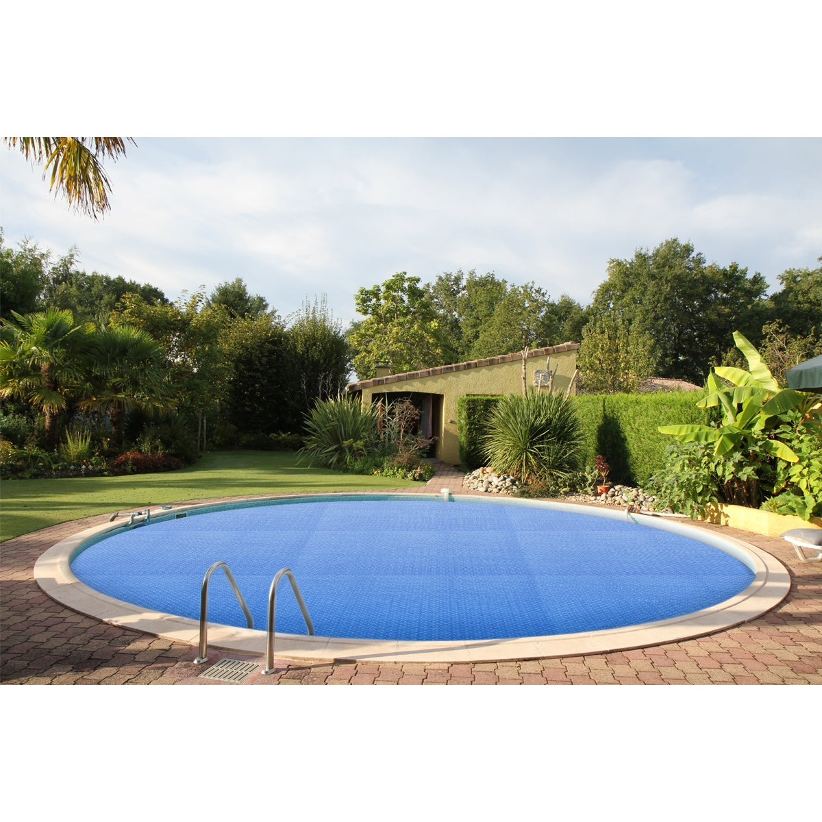 Runder Pool mit blauer Solarfolie und umgebender Gartenlandschaft.