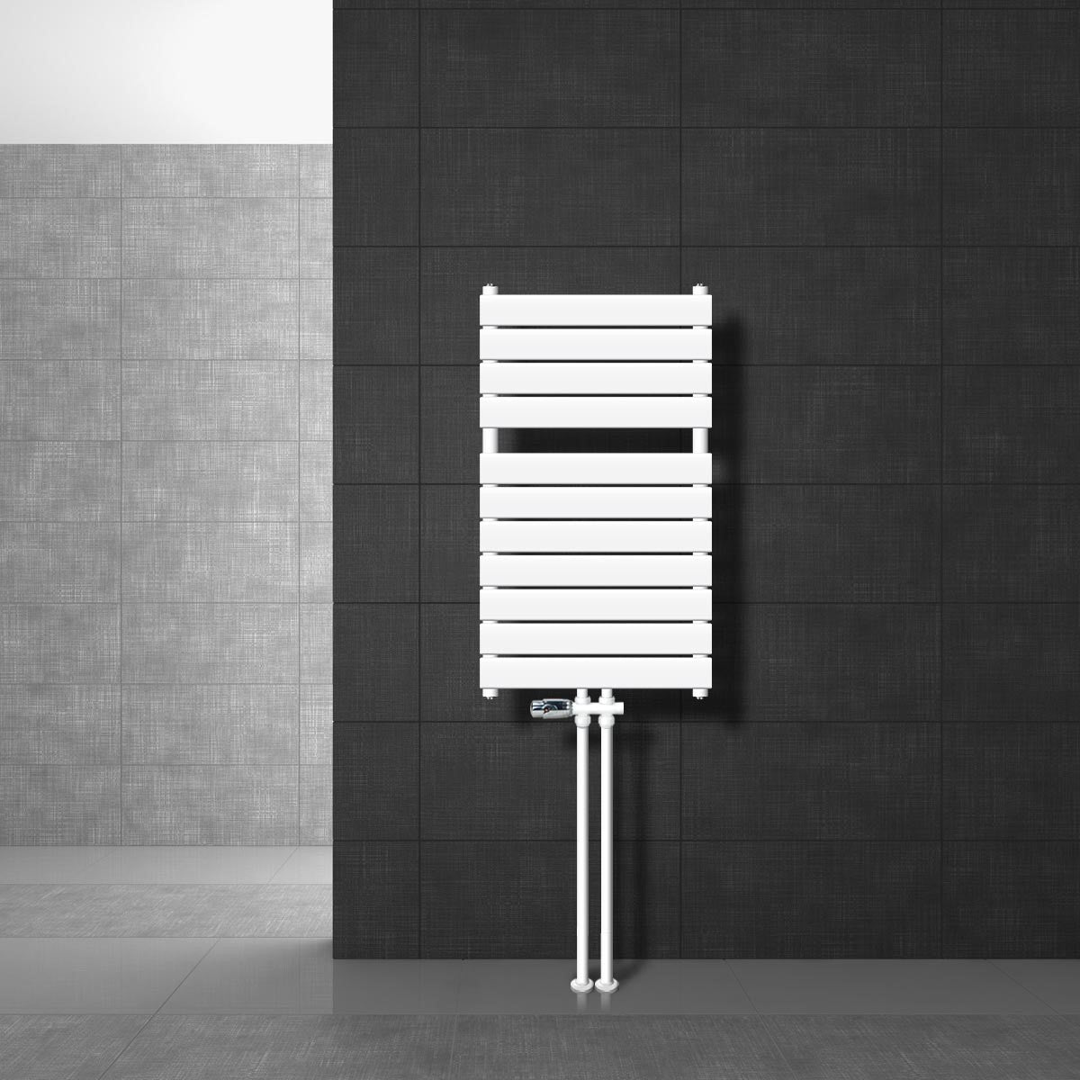 Vit radiator med rör på en mörk vägg.