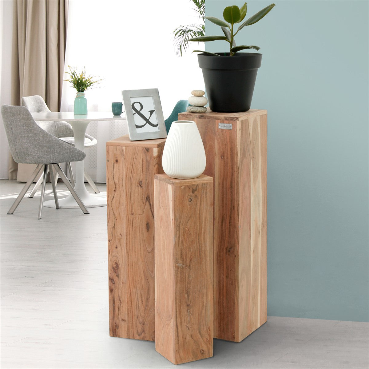 Houten standaard met plant, vaas en decoratie tegen een lichte achtergrond.